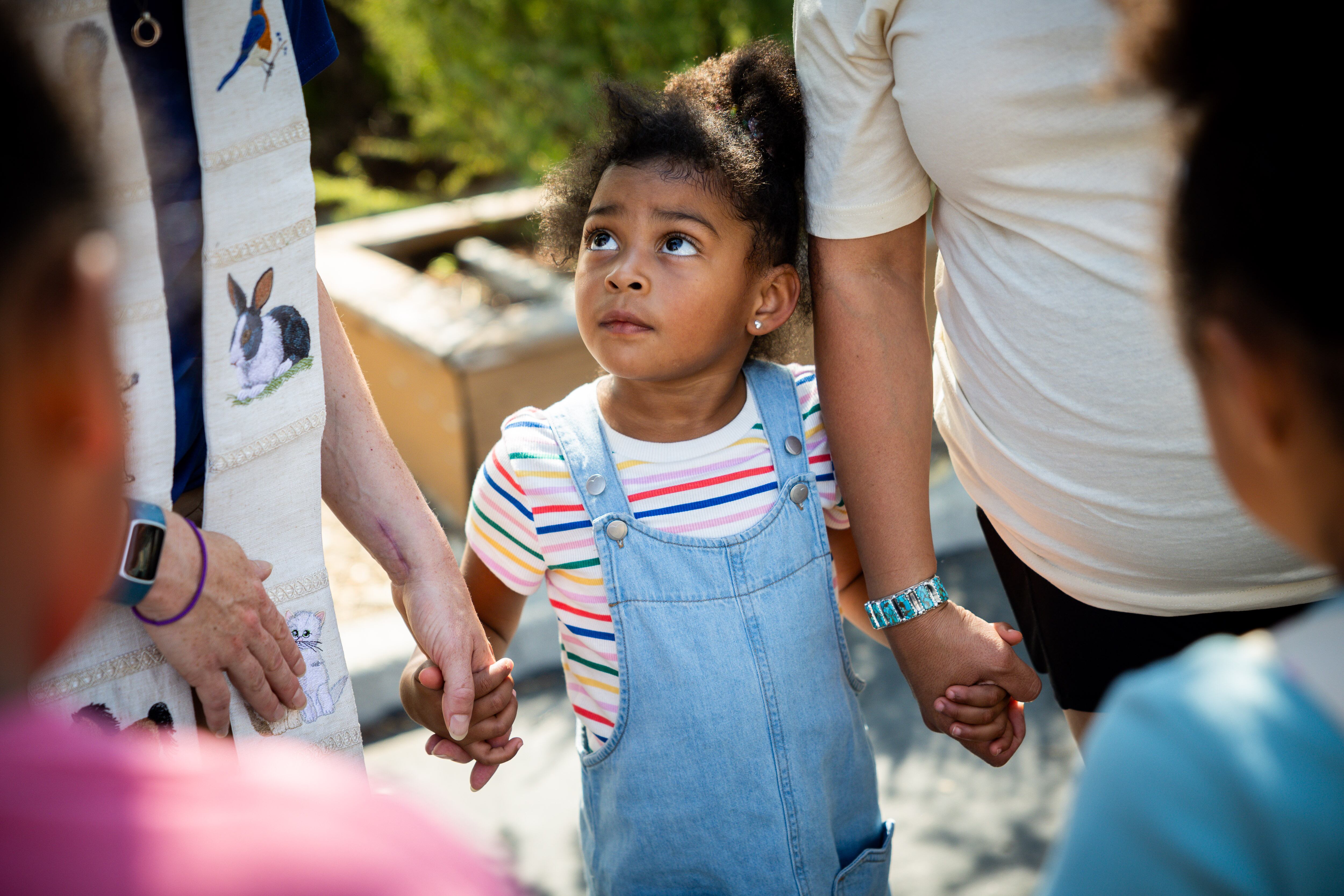 Amina Adan, 4, center, looks up at Pastor Sarah Merchant as she blesses Adan’s family after their cat went missing during a Blessing of the Animals in conjunction with the celebration of the Hilltop United Methodist Church’s 125th anniversary at Hilltop United Methodist Church in Sandy on Saturday.