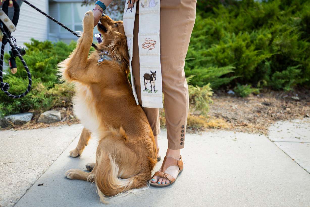 Pastor Sarah Merchant, right, blesses Biscuit, left, during a Blessing of the Animals in conjunction with the celebration of the Hilltop United Methodist Church’s 125th anniversary at Hilltop United Methodist Church in Sandy on Saturday.
