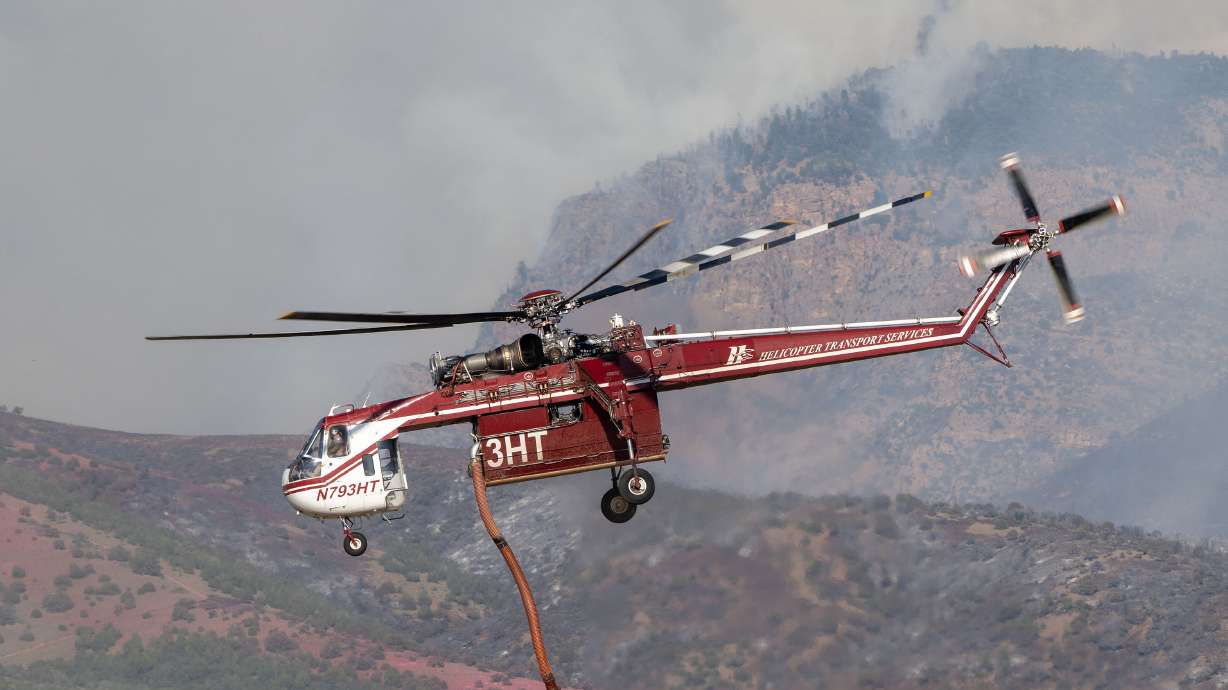 A Sikorsky Skycrane lifts after refilling as crews fight the Widemouth 2 Fire east of Fillmore on Aug. 4. One of the pilots killed in a crash on Friday was identified on Monday as a California-based firefighter by his hometown.