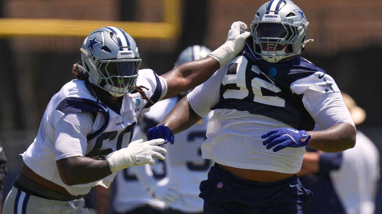 Dallas Cowboys offensive tackle Tyler Guyton, left, holds defensive tackle Quinnen Williams back during the NFL football team's training camp, Saturday, Aug. 1, 2026, in Oxnard, Calif.