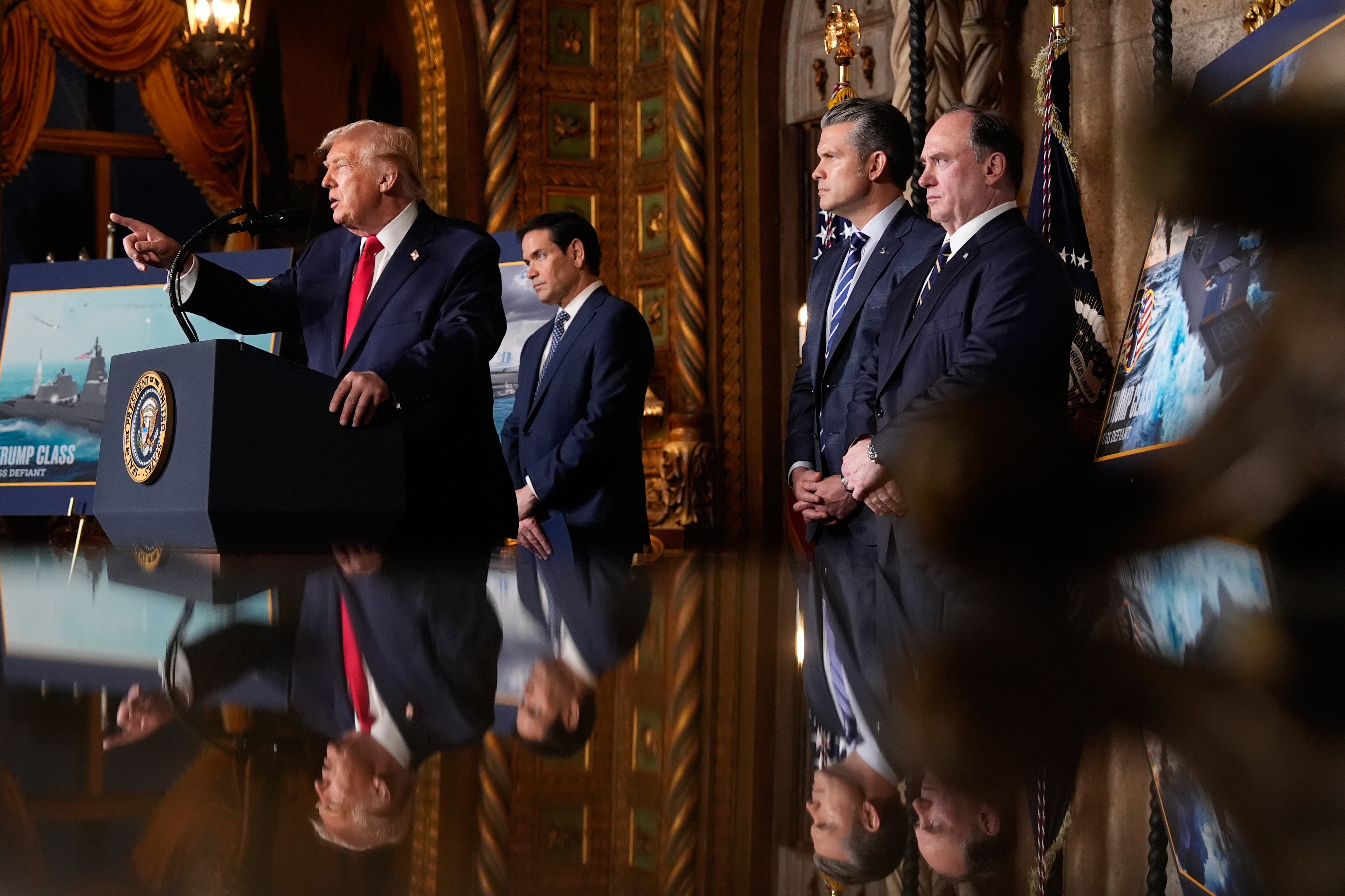 President Donald Trump speaks, with from left, Secretary of State Marco Rubio, Defense Secretary Pete Hegseth and Secretary of the Navy John Phelan,at his Mar-a-Lago club, Monday, Dec. 22, 2025, in Palm Beach, Fla.