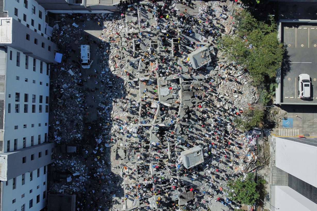 Residents and rescue workers search through the rubble after an earthquake struck Cali, Colombia, Monday.