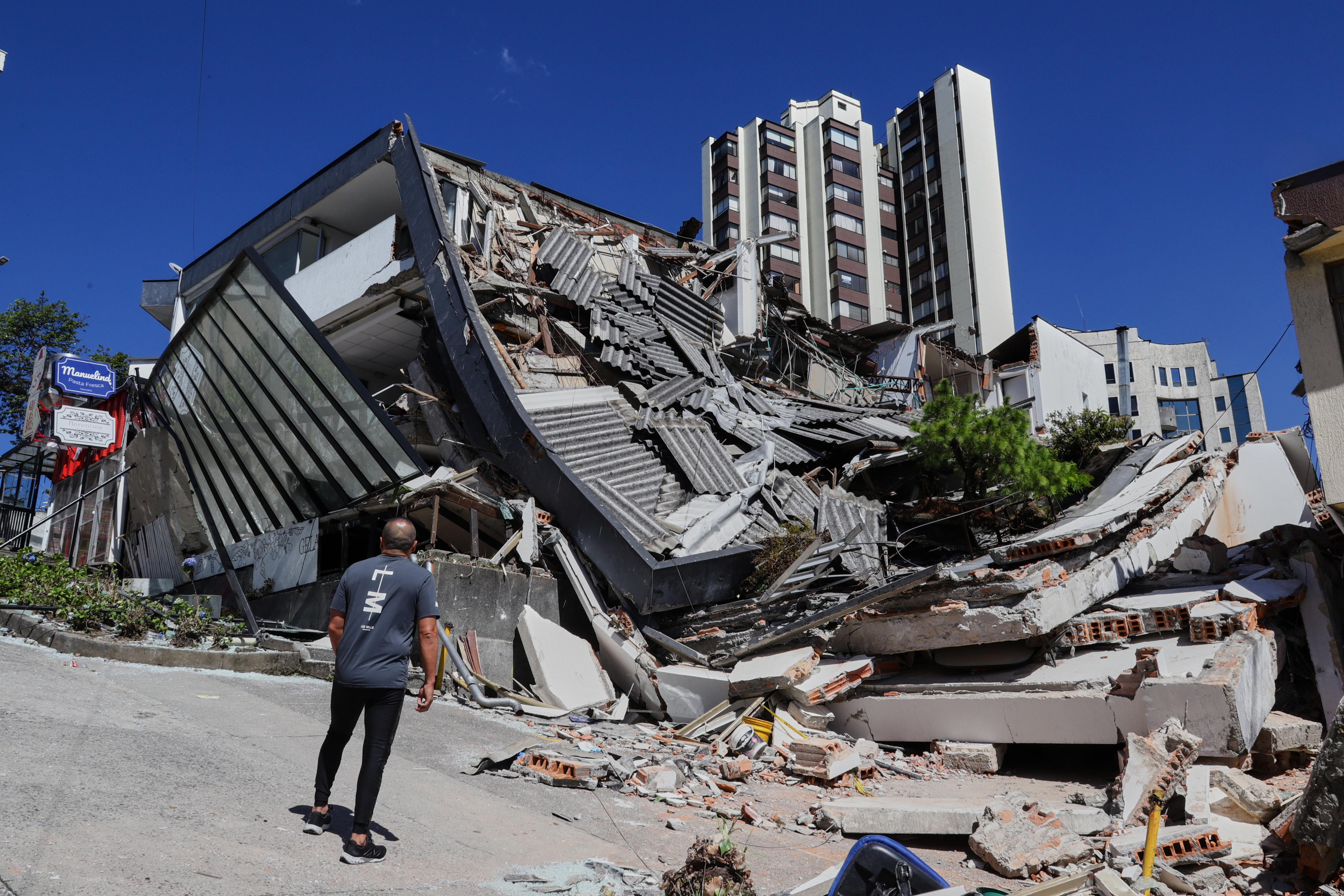 A man looks at a collapsed building after an earthquake struck Manizales, Colombia, Monday.