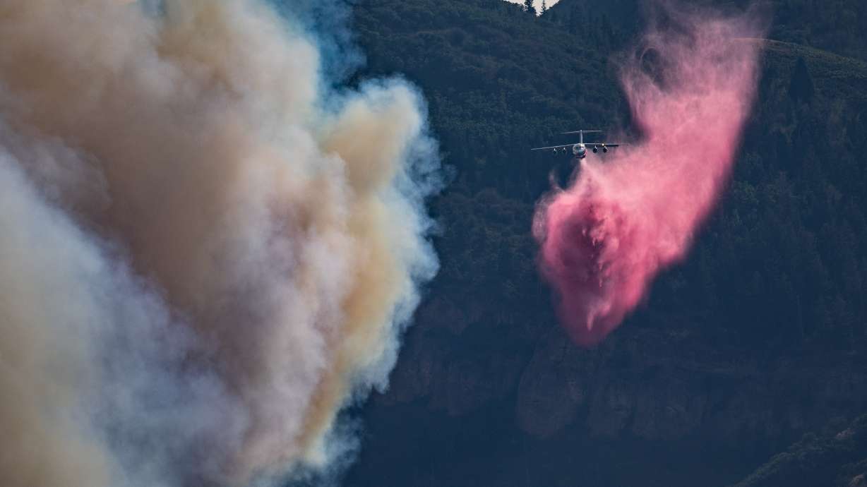 Firefighters release fire retardant on the Rocky Canyon Fire near Henefer on Monday. The town was evacuated as fire intensity picked up in the afternoon.