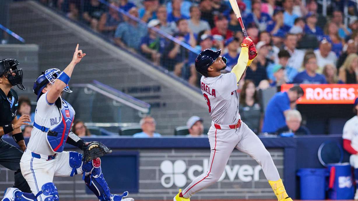 Boston Red Sox's Ceddanne Rafaela, right, flies into a sacrifice double play that was reviewed with a time play allowing Anthony Seigler (not shown) to score against the Toronto Blue Jays during the seventh inning of a baseball game in Toronto, Monday, Aug. 10, 2026.