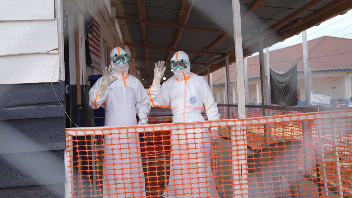 Health workers in protective gear wave inside an Ebola treatment center in Bunia, Congo, Monday. Government data on Wednesday showed the outbreak has killed over 2,000 people.
