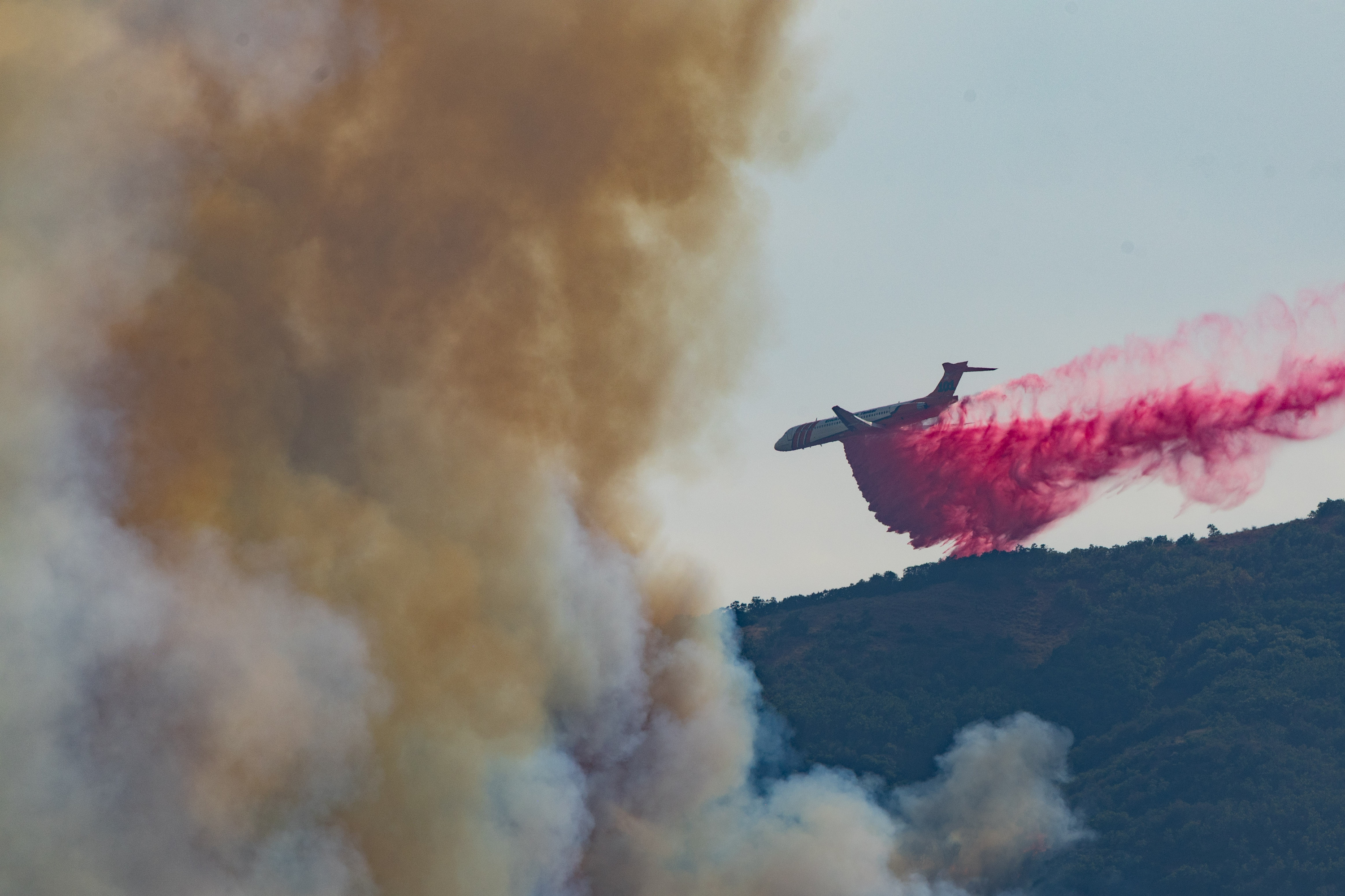 A plane drops fire retardant around the Rocky Canyon Fire near Henefer on Monday.