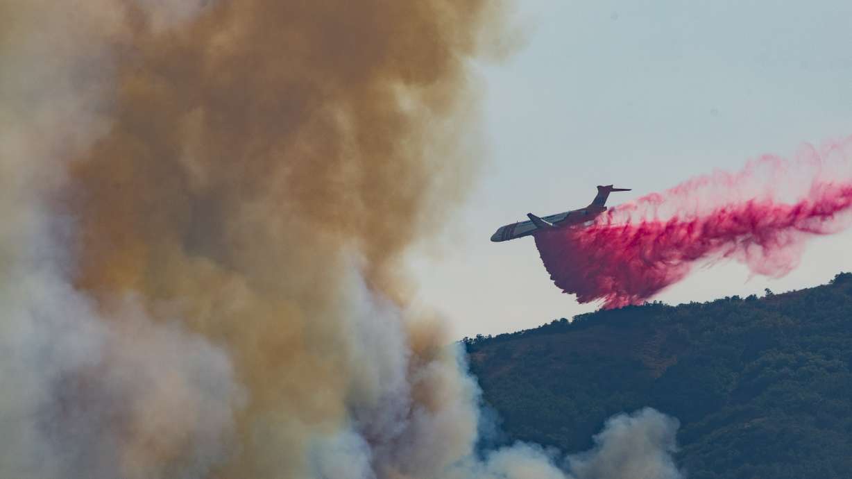 A plane drops fire retardant around the Rocky Canyon Fire near Henefer on Monday.