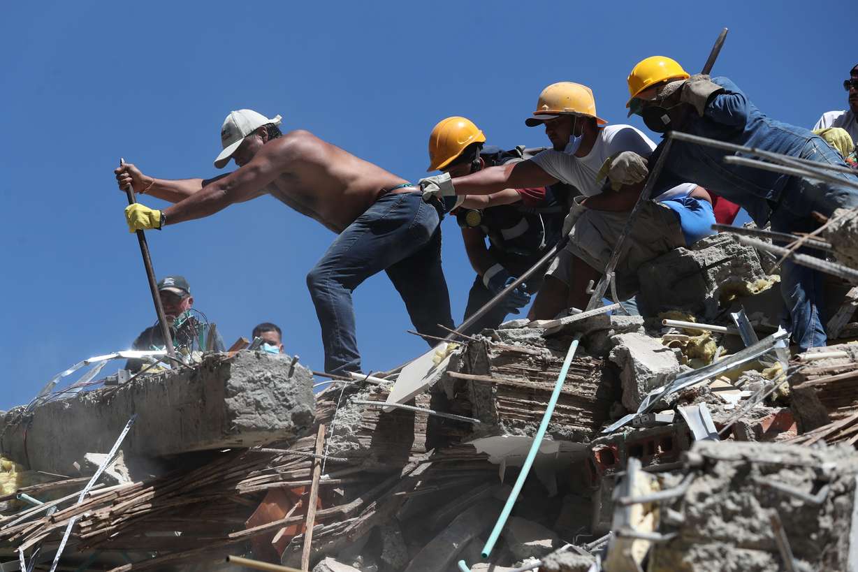Residents and rescue workers search through the rubble after an earthquake struck Cali, Colombia, on Monday. At least 181 people have been killed as of Tuesday.