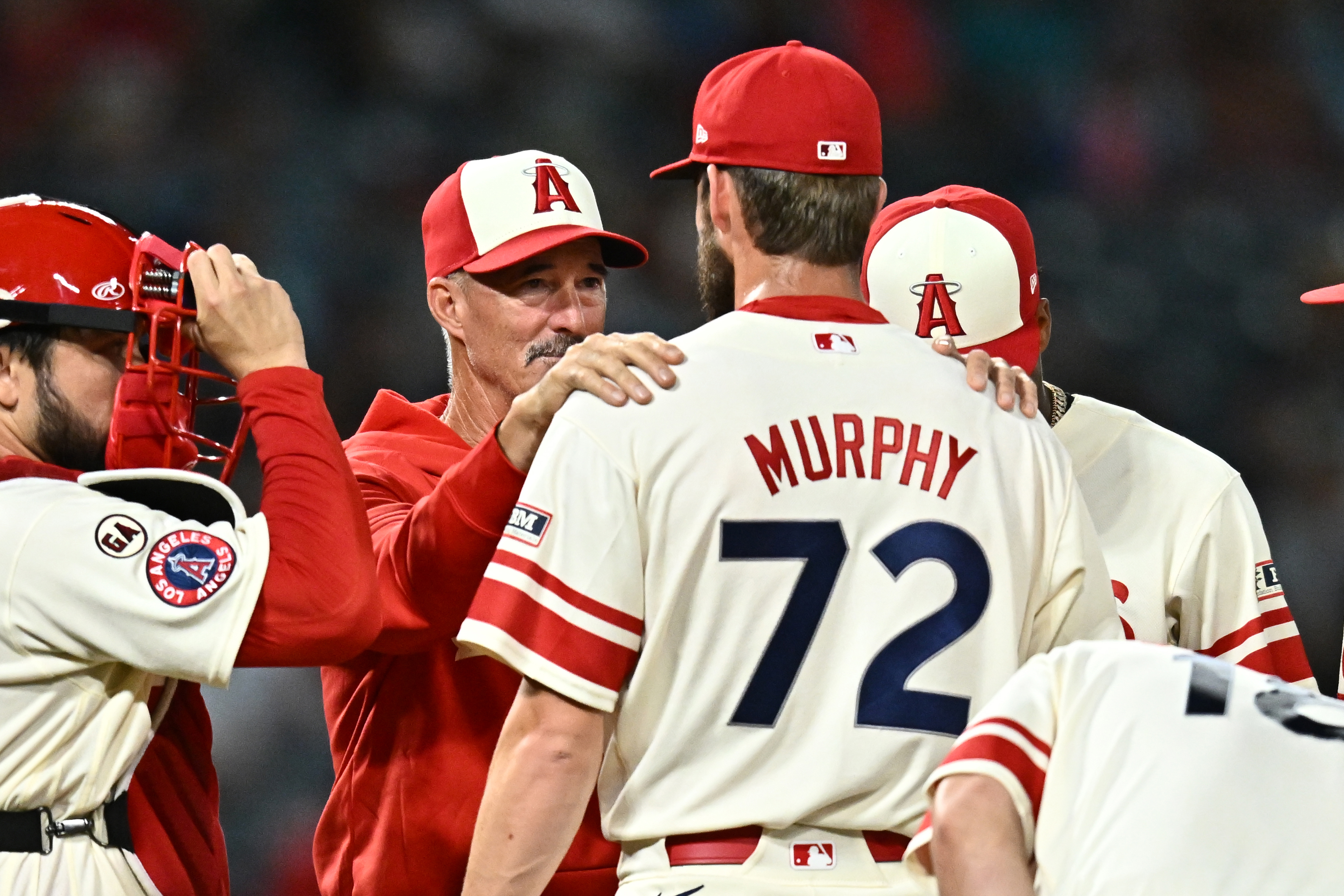 Los Angeles Angels pitcher Luke Murphy (72) speaks with pitching coach Mike Maddux, second from left, during the eighth inning of a baseball game against the Milwaukee Brewers, Friday, July 31, 2026, in Anaheim, Calif. 