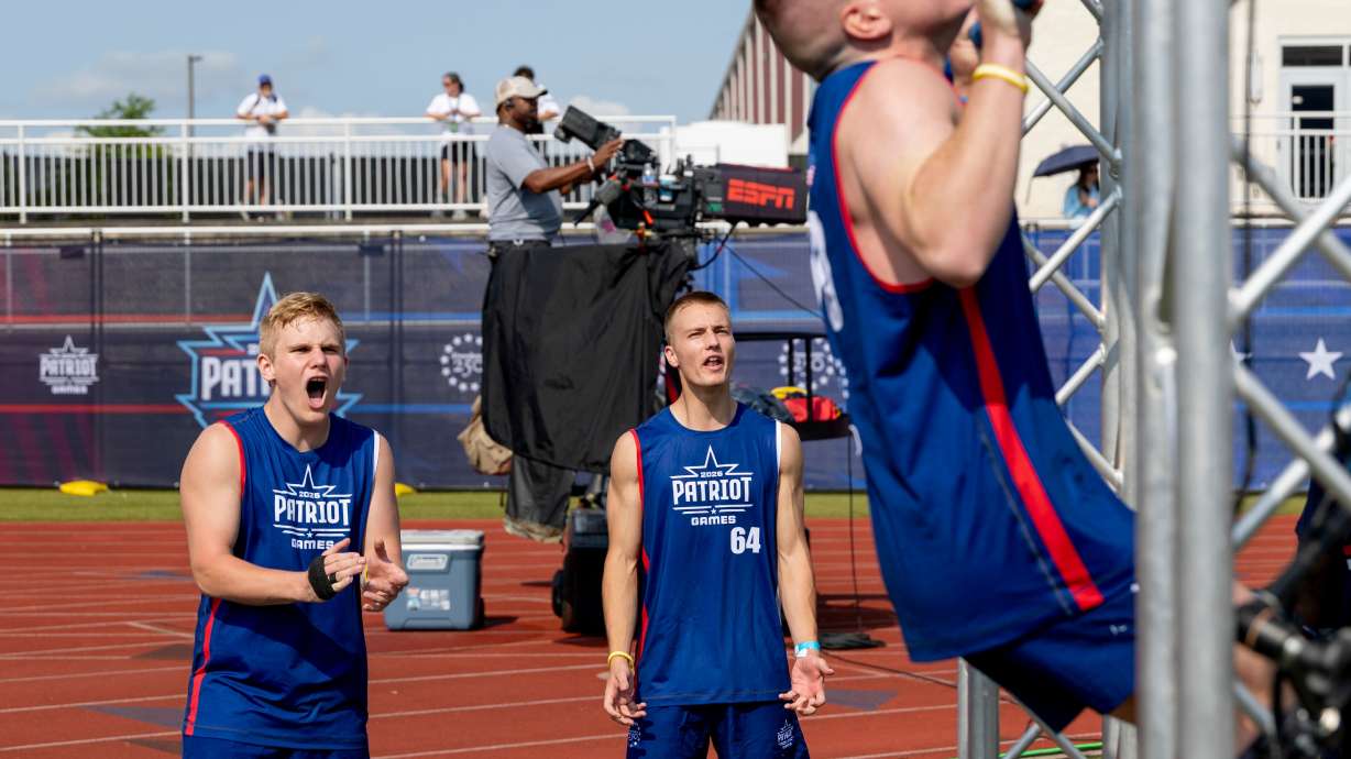 Utah's Rockwell Myers, middle, watches Gabriel Hayes of the Shawnee Tribe, right, cheers on other participants during day one of the Patriot Games, Sunday, in Geneva, Ohio.