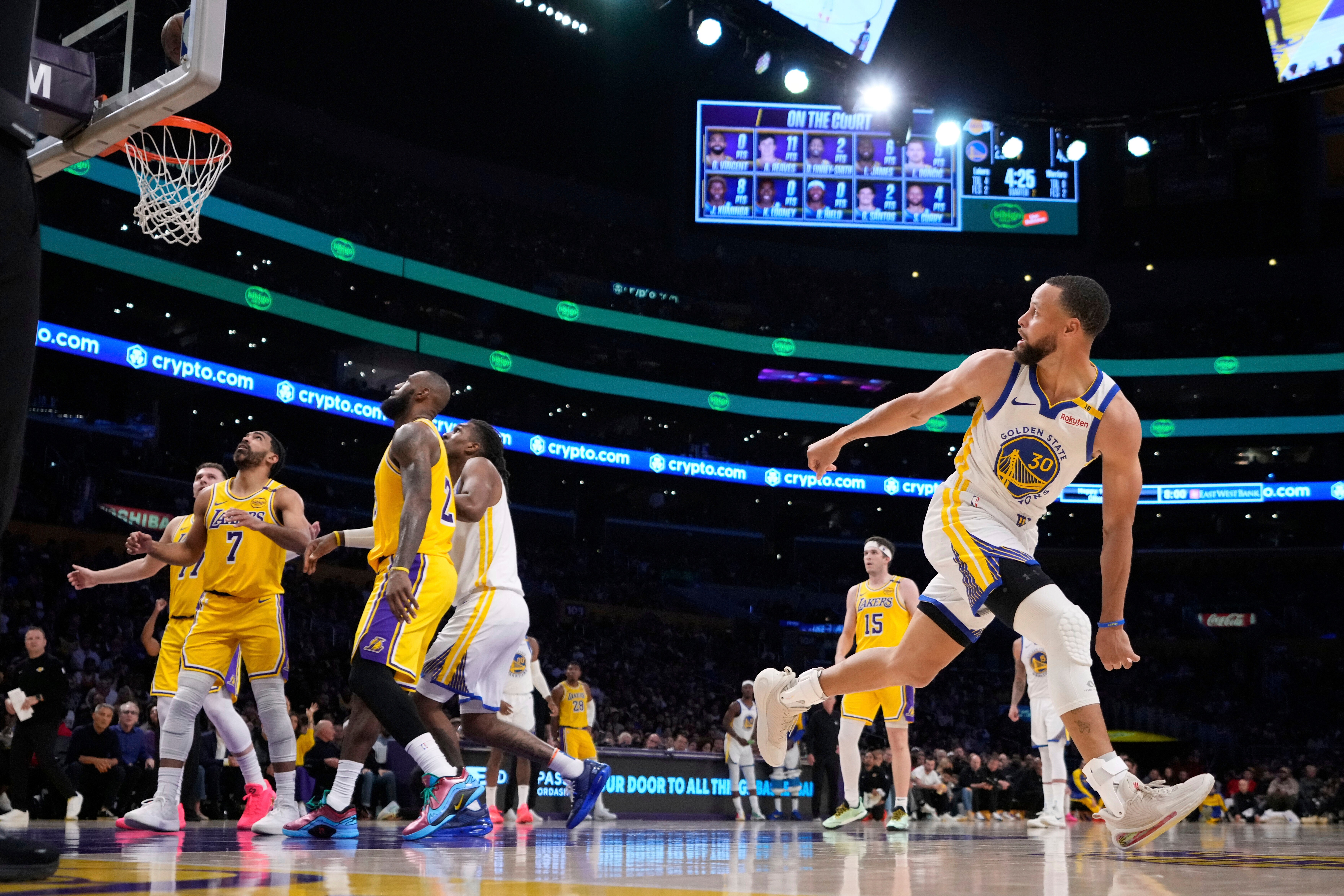 FILE - Golden State Warriors guard Stephen Curry, right, watches his shot go in during the first half of an NBA basketball game against the Los Angeles Lakers in Los Angeles., April 3, 2025. 