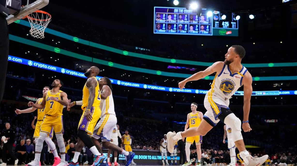 FILE - Golden State Warriors guard Stephen Curry, right, watches his shot go in during the first half of an NBA basketball game against the Los Angeles Lakers in Los Angeles., April 3, 2025.