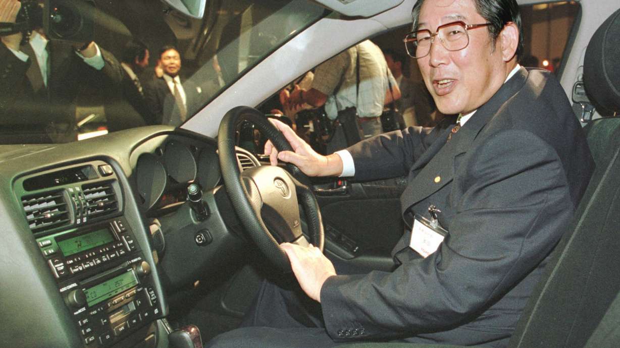 Hiroshi Okuda, then, president of Toyota Motor Corp., smiles as he sits at the steering wheel of the "Aristo," Toyota's remodeled sports sedan during a press conference at a Tokyo hotel, Aug. 27, 1997.