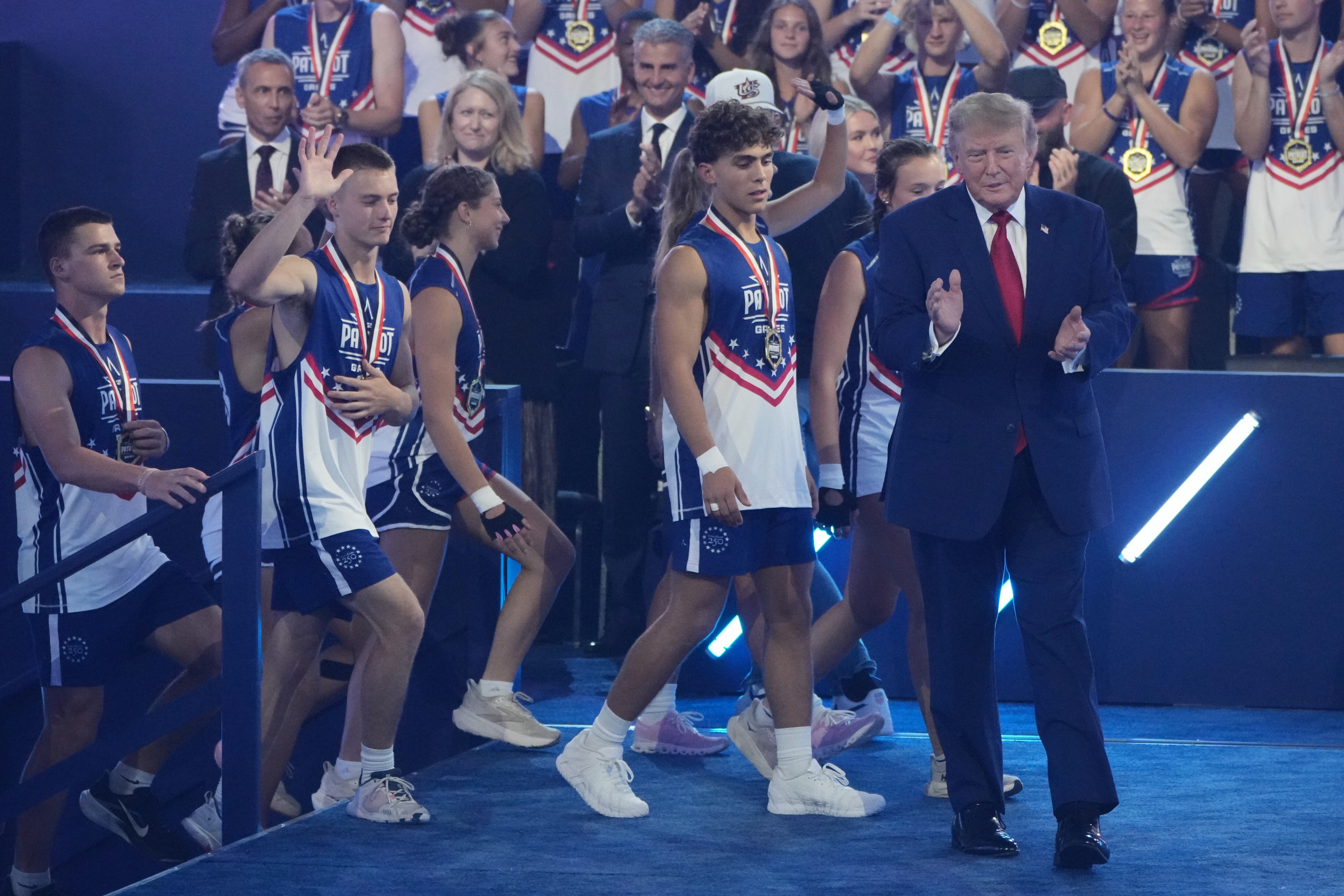 President Donald Trump walks onto stage with athletes at the Patriot Games at Spire Academy in Geneva, Ohio, on Tuesday.