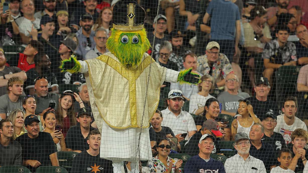Chicago White Sox mascot Southpaw stands on the dugout wearing a pope outfit during the seventh inning of a baseball game against the Cincinnati Reds, Tuesday, Aug. 11, 2026, in Chicago.