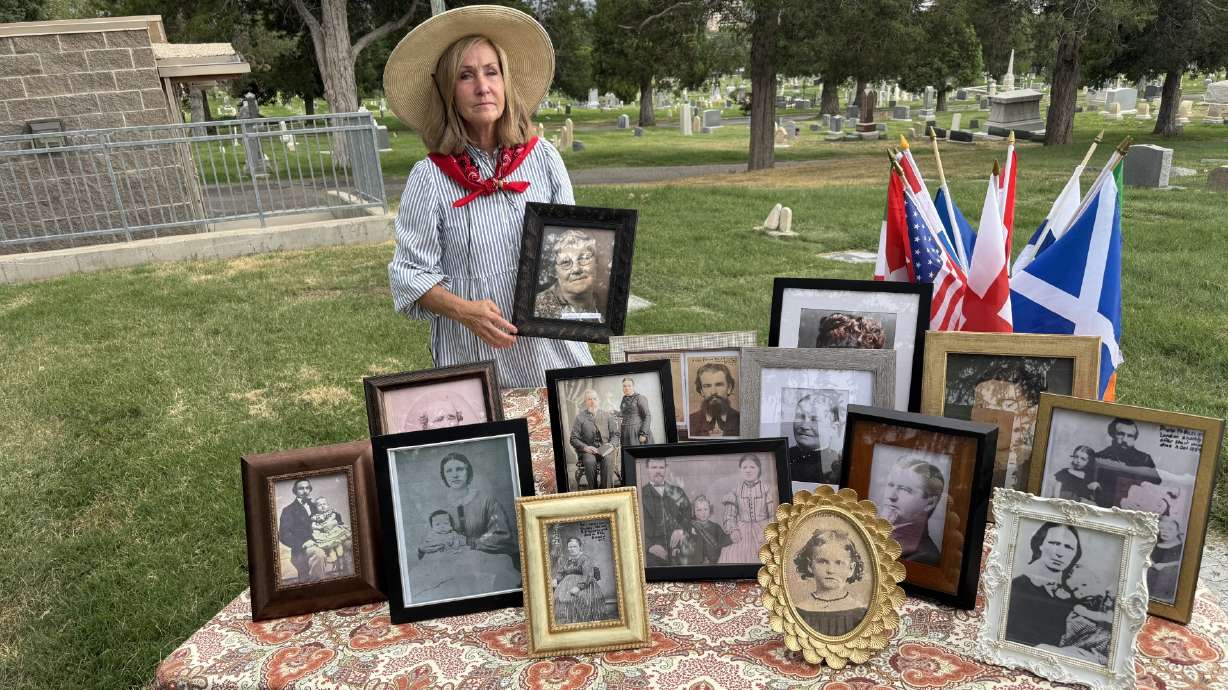 Becky Anderson displays photos of pioneers and others connected to paupers' graves at the Salt Lake City Cemetery