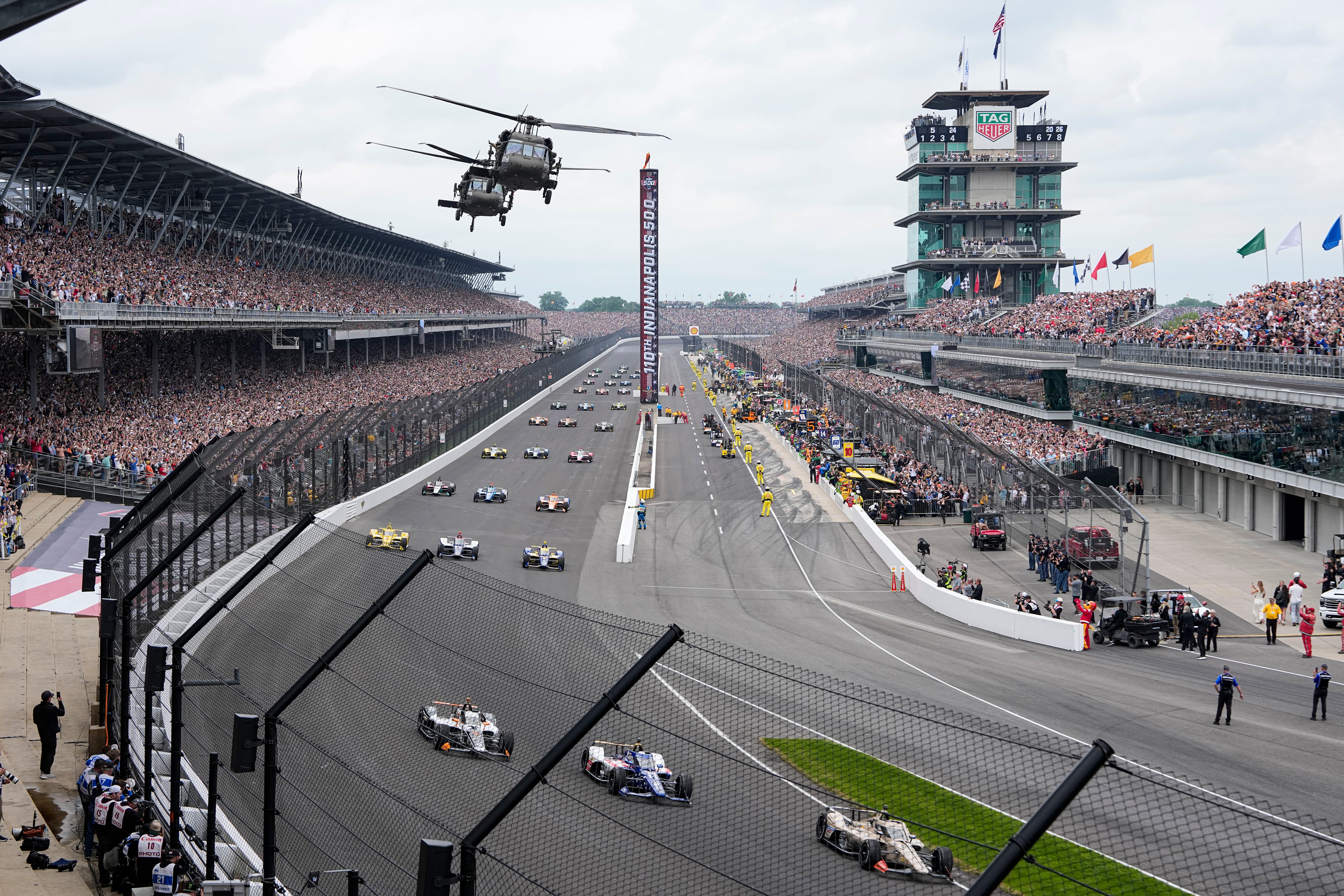 FILE - Helicopters fly over the field on the parade lap before the Indianapolis 500 auto race in Indianapolis, May 24, 2026. 