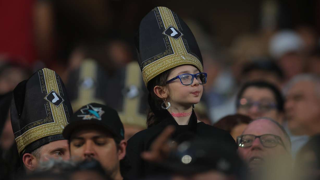 A fan wears a promotional pope hat during a baseball game between the Cincinnati Reds and Chicago White Sox, Tuesday, Aug. 11, 2026, in Chicago.