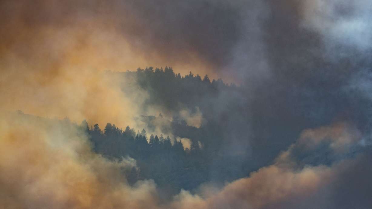A wildfire burns in Rocky Canyon near Henefer on Monday. The record-breaking season is not done yet, despite hundreds of structures already being lost and millions already cost in resources.