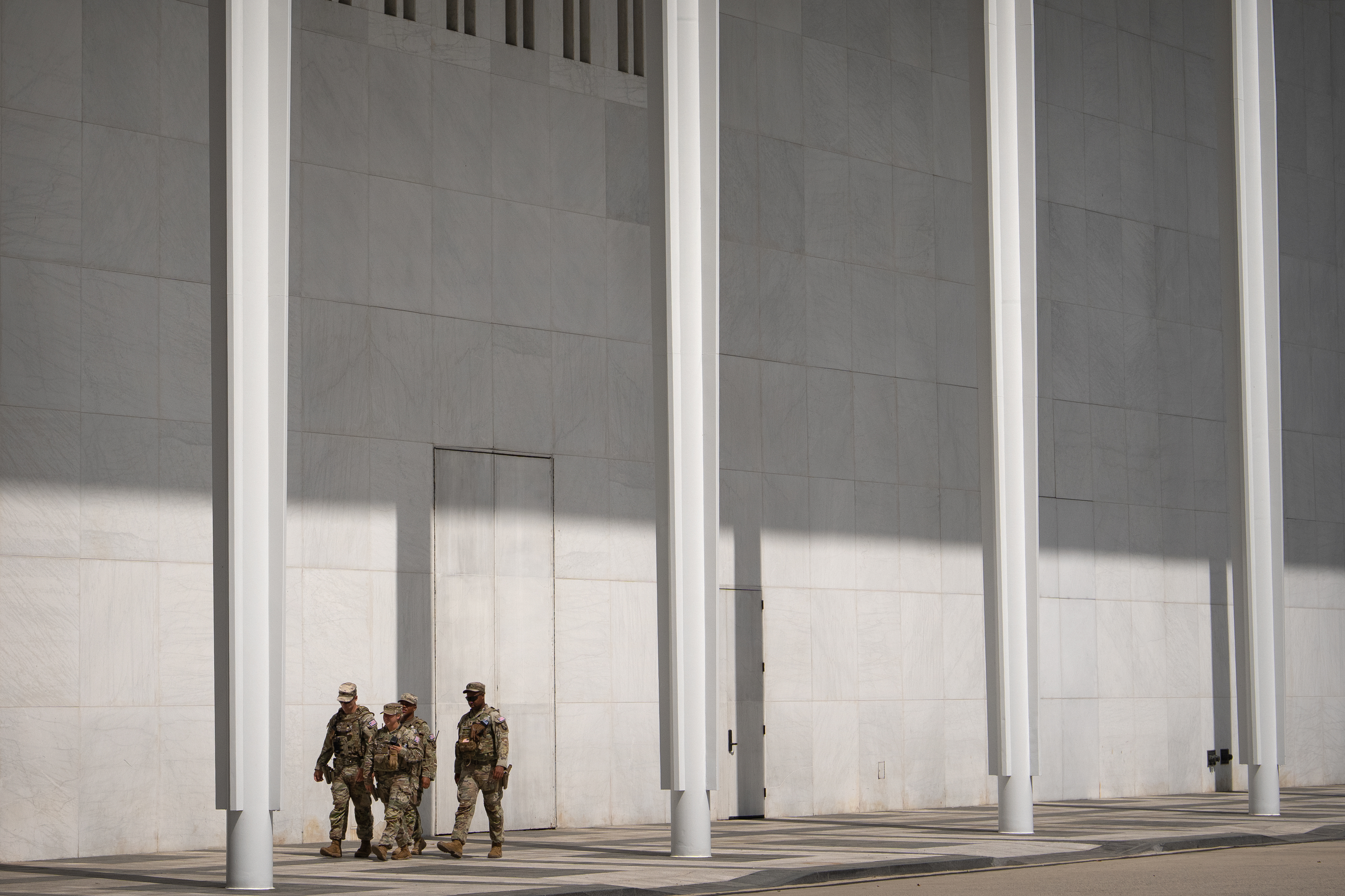National Guard members walk outside of the Kennedy Center, July 31, in Washington. The center has become a visible symbol of presidential power.