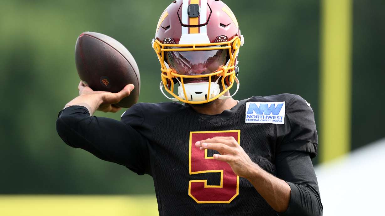 Washington Commanders quarterback Jayden Daniels works out before a joint practice with the Miami Dolphins at NFL football training camp, Wednesday, Aug. 12, 2026 in Ashburn, Va.