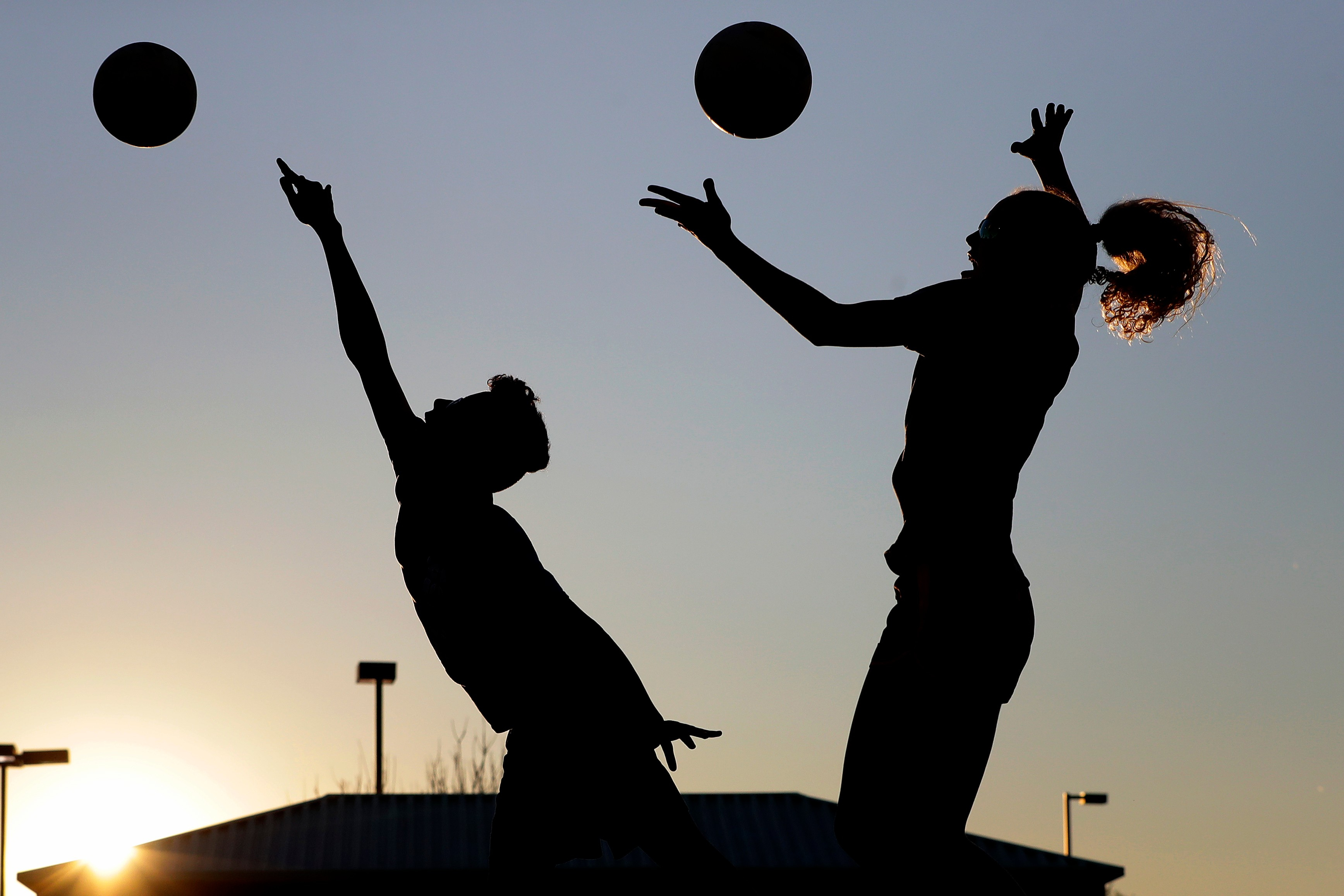 FILE - Friends practice volleyball at a local park in Gilbert, Ariz., March 15, 2020. 