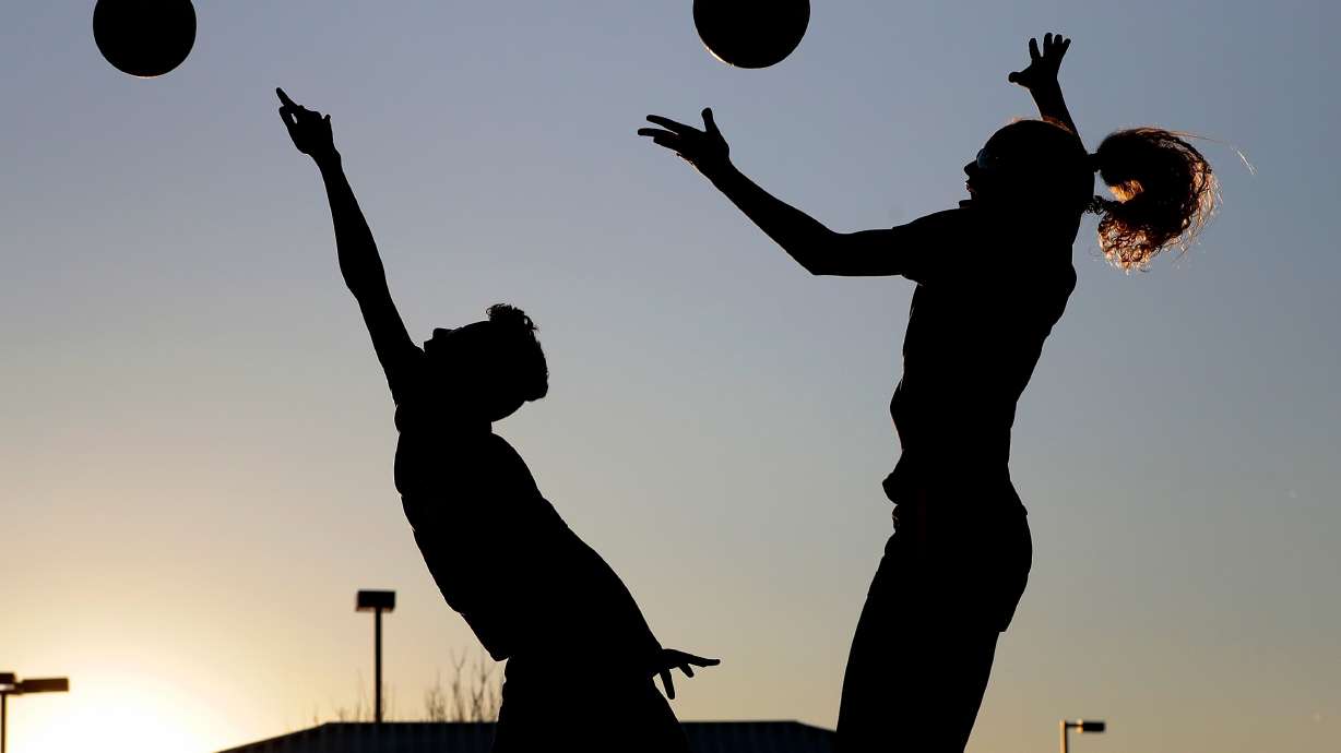 FILE - Friends practice volleyball at a local park in Gilbert, Ariz., March 15, 2020.