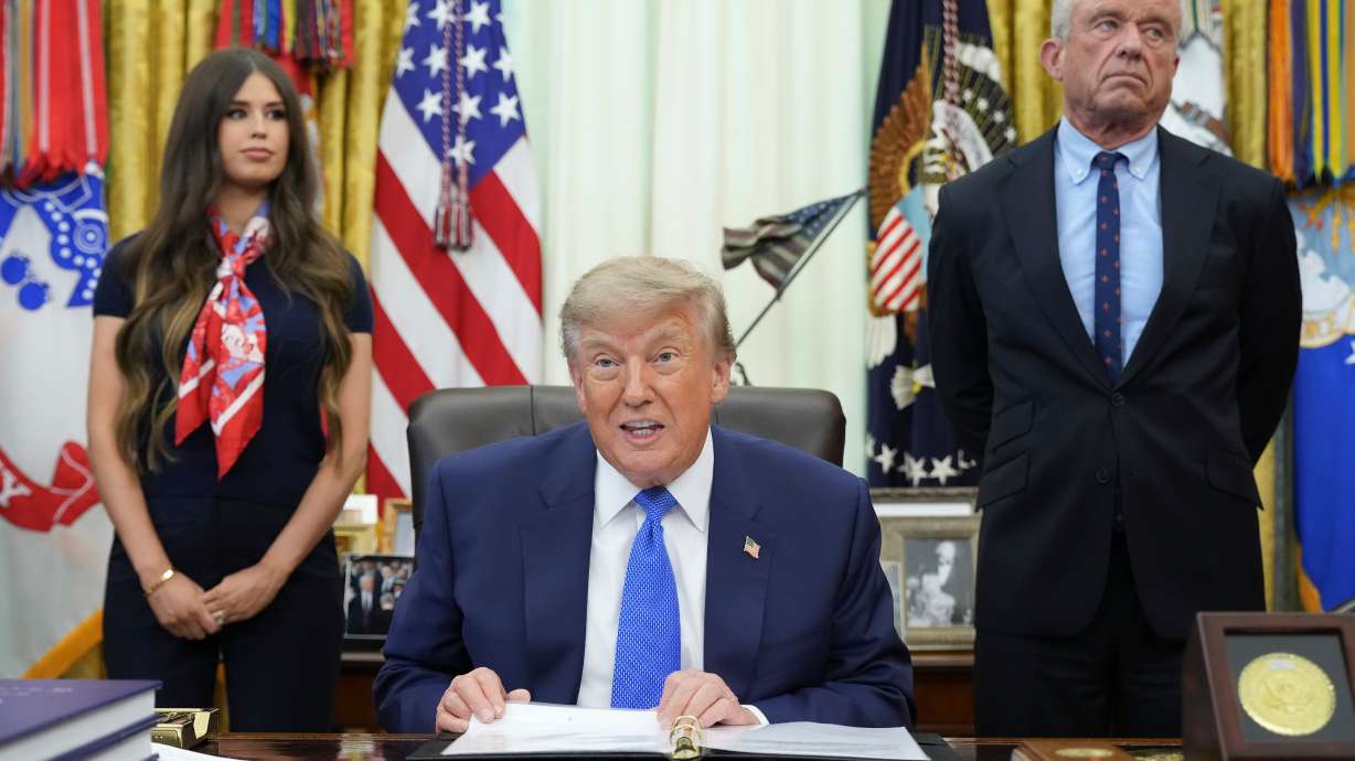 President Donald Trump speaks as Health and Human Services Secretary Robert F. Kennedy Jr., right, and Jayme Franklin listen during a meeting to sign an executive order about vaccines, Monday, in the Oval Office of the White House in Washington.