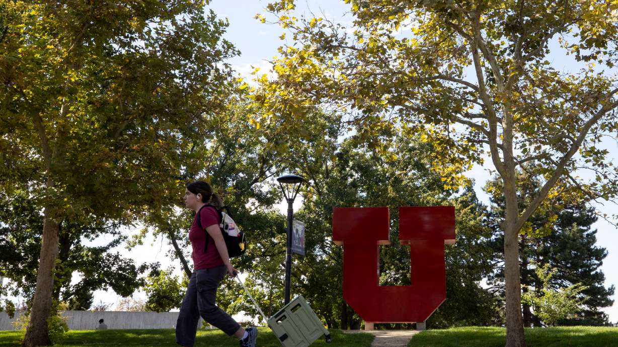 A student rolls a case through the University of Utah campus in Salt Lake City on Sept. 26, 2025. The University of Utah's board of trustees on Tuesday approved budgets for U. Health, ARUP Laboratories and the general university-wide operating budget.