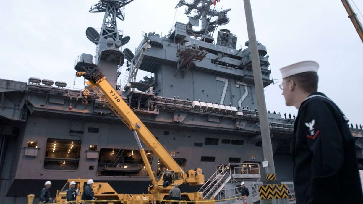 Travis Clark, right, watches as the USS Abraham Lincoln prepares to leave Naval Station Everett in Washington state, Friday, Oct. 15, 2004. Stark challenges are being reported in recent weeks aboard the long-deployed USS Abraham Lincoln.