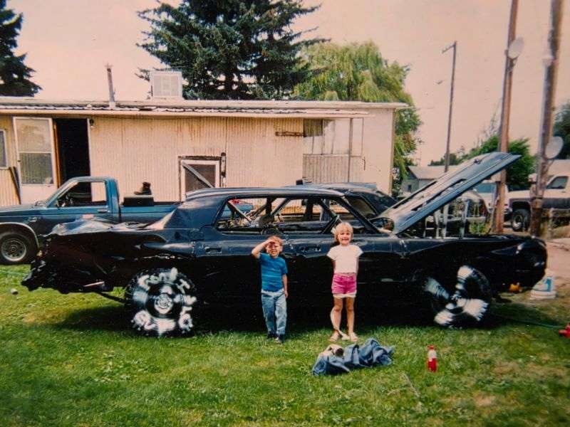 A girl and boy pose in front of a future Eastern Idaho State Fair demolition derby car in this undated photo. The girl would later grow up to drive that same car in the Powder Puff Derby, showing the derby is a family affair.