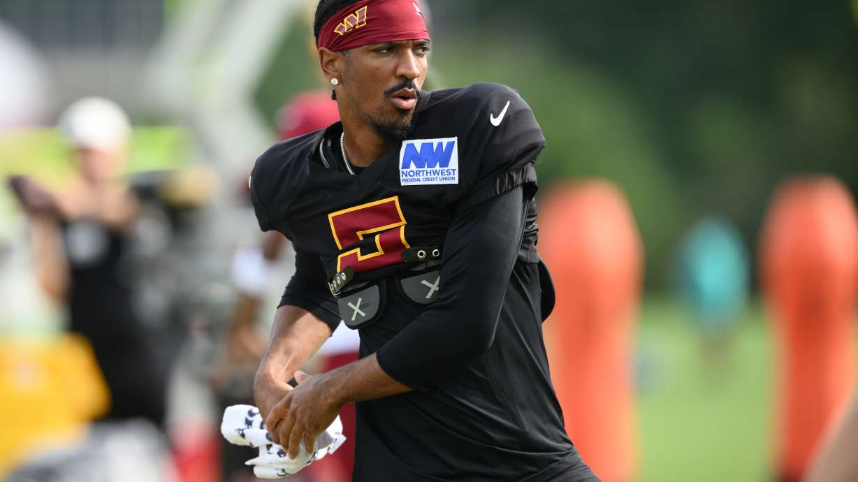 Washington Commanders quarterback Jayden Daniels works out before a joint practice with the Miami Dolphins at NFL football training camp, Wednesday, Aug. 12, 2026 in Ashburn, Va.