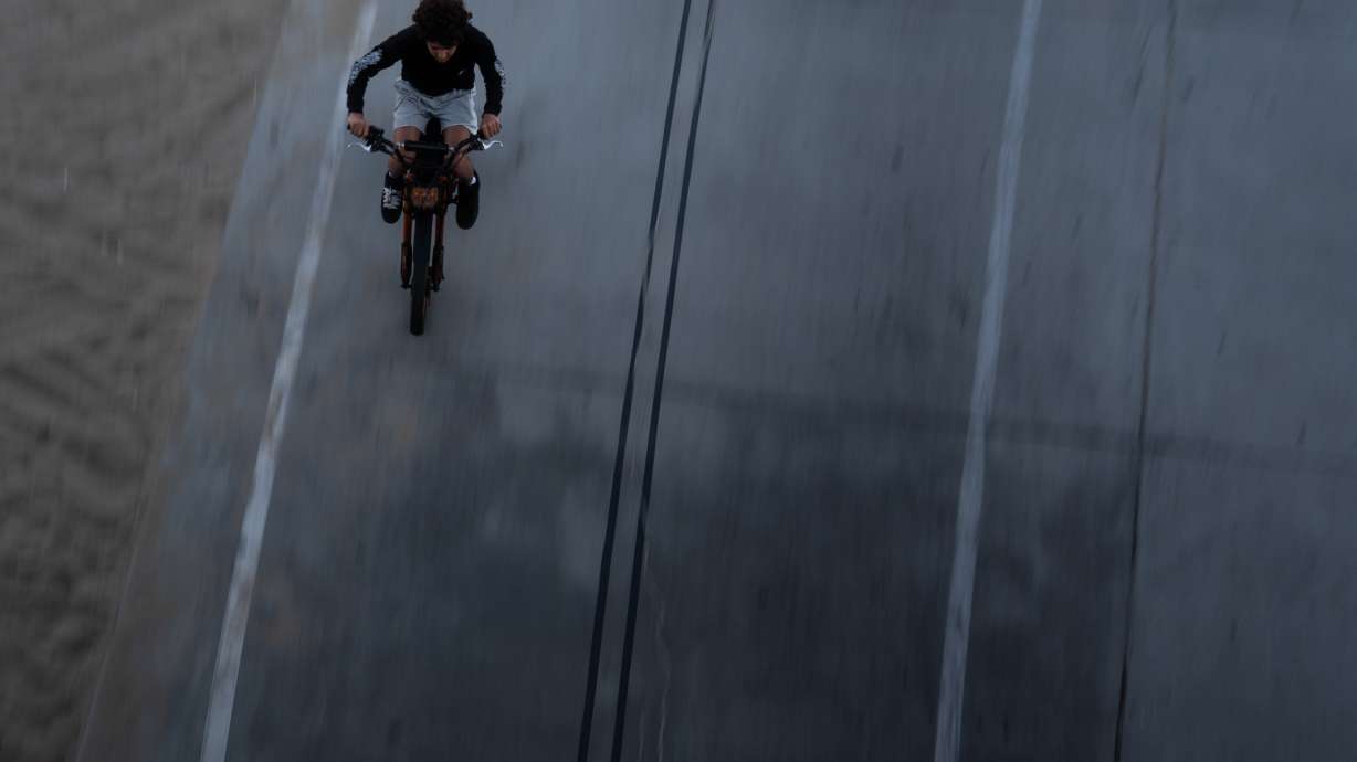 A boy rides an e-bike in Santa Monica, Calif., Monday.