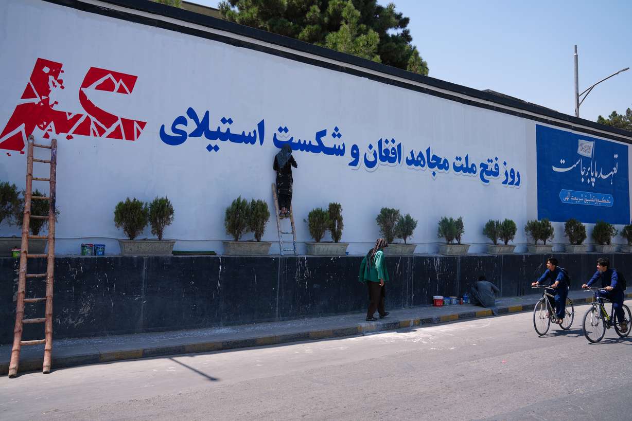 Workers paint a mural celebrating the Taliban's victory and the defeat of the U.S.-led occupation ahead of celebrations marking five years of Taliban rule, in Kabul, Afghanistan, Thursday.