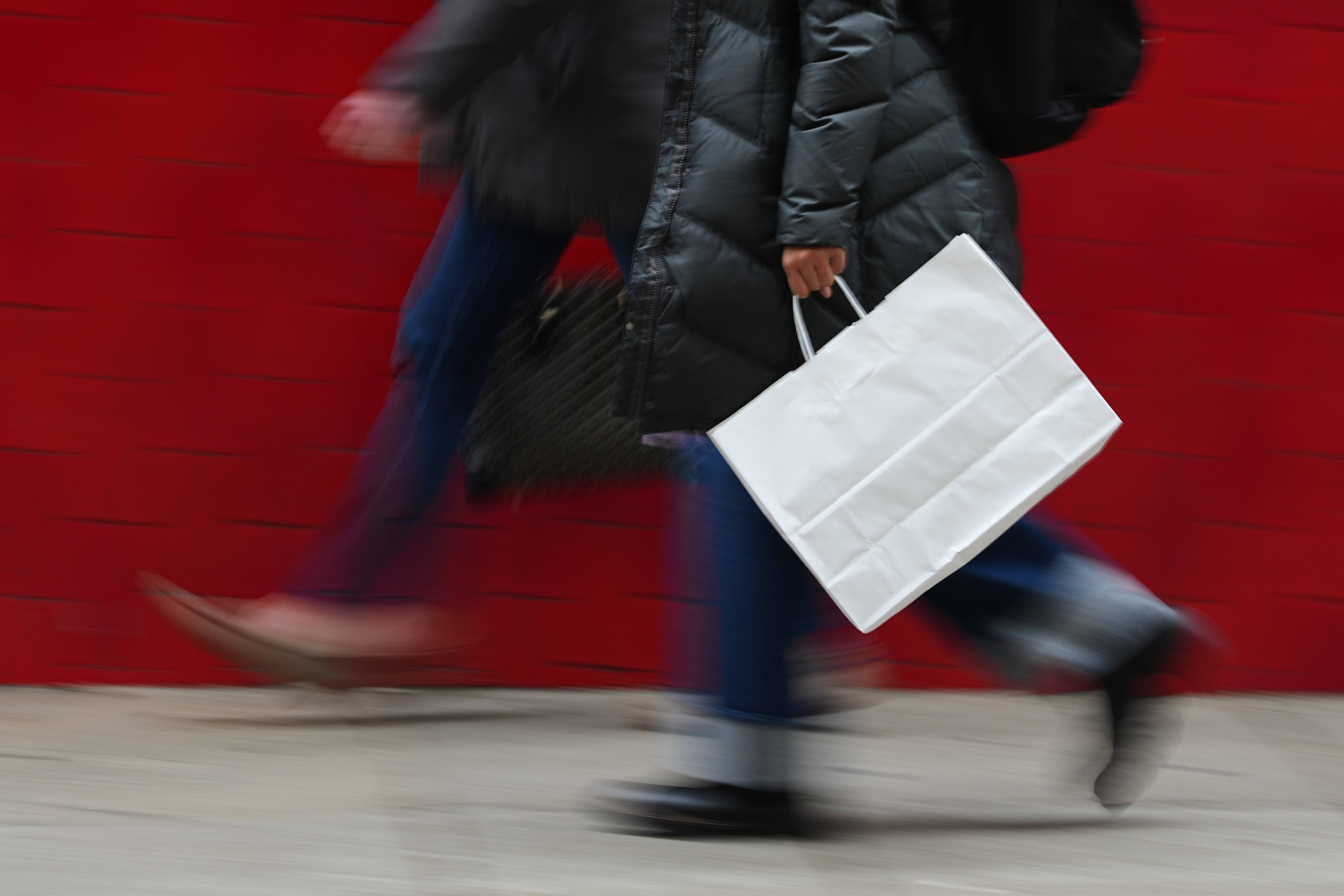 A person carries a shopping bag in Philadelphia, Dec. 10, 2025.