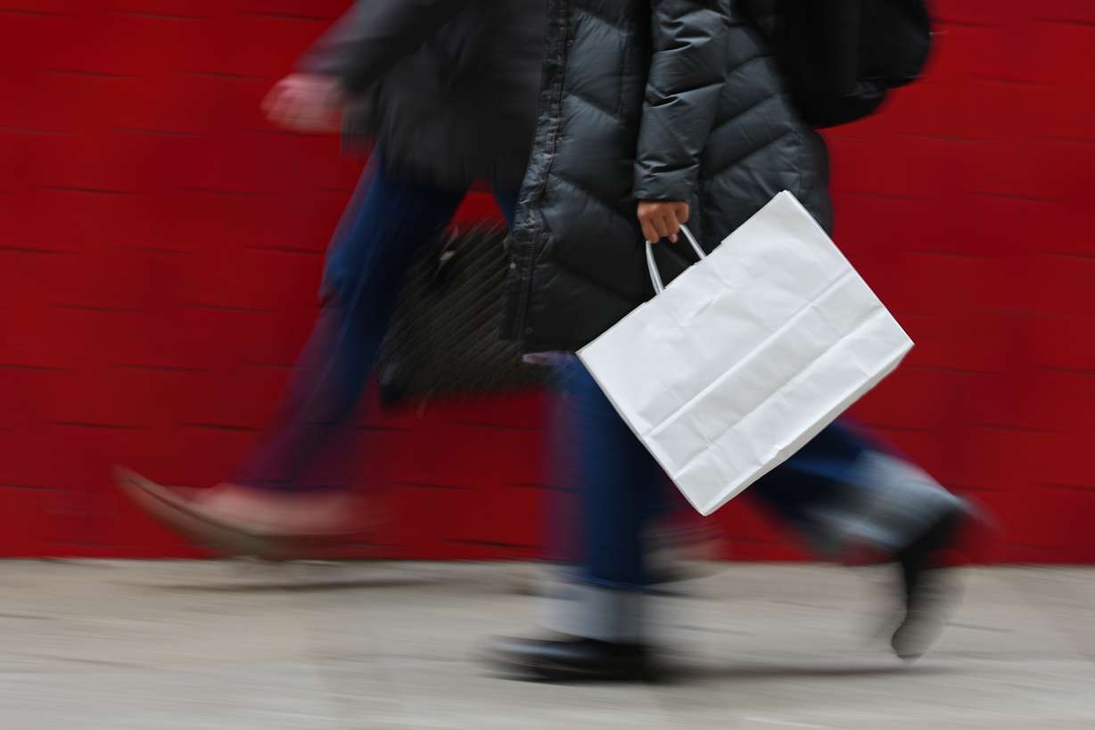 A person carries a shopping bag in Philadelphia, Dec. 10, 2025.