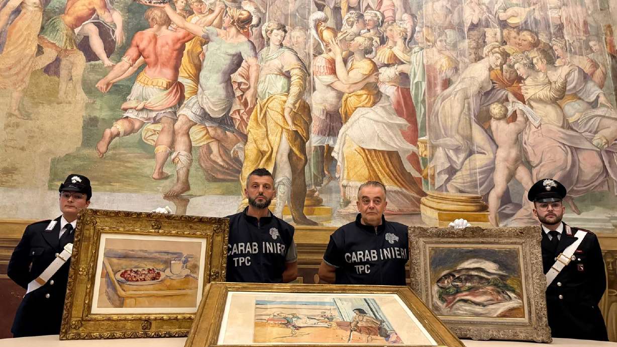 In this picture made available by the Italian Carabinieri in Parma, northern Italy, Friday, Carabinieri pose near three paintings recovered following a police operation: "Tasse et plat de cerises" by Paul Cezanne, left, "Odalisque Sur La Terrasse" by Henri Matisse, center, and "Les Poisson" by Pierre Auguste Renoir, right.
