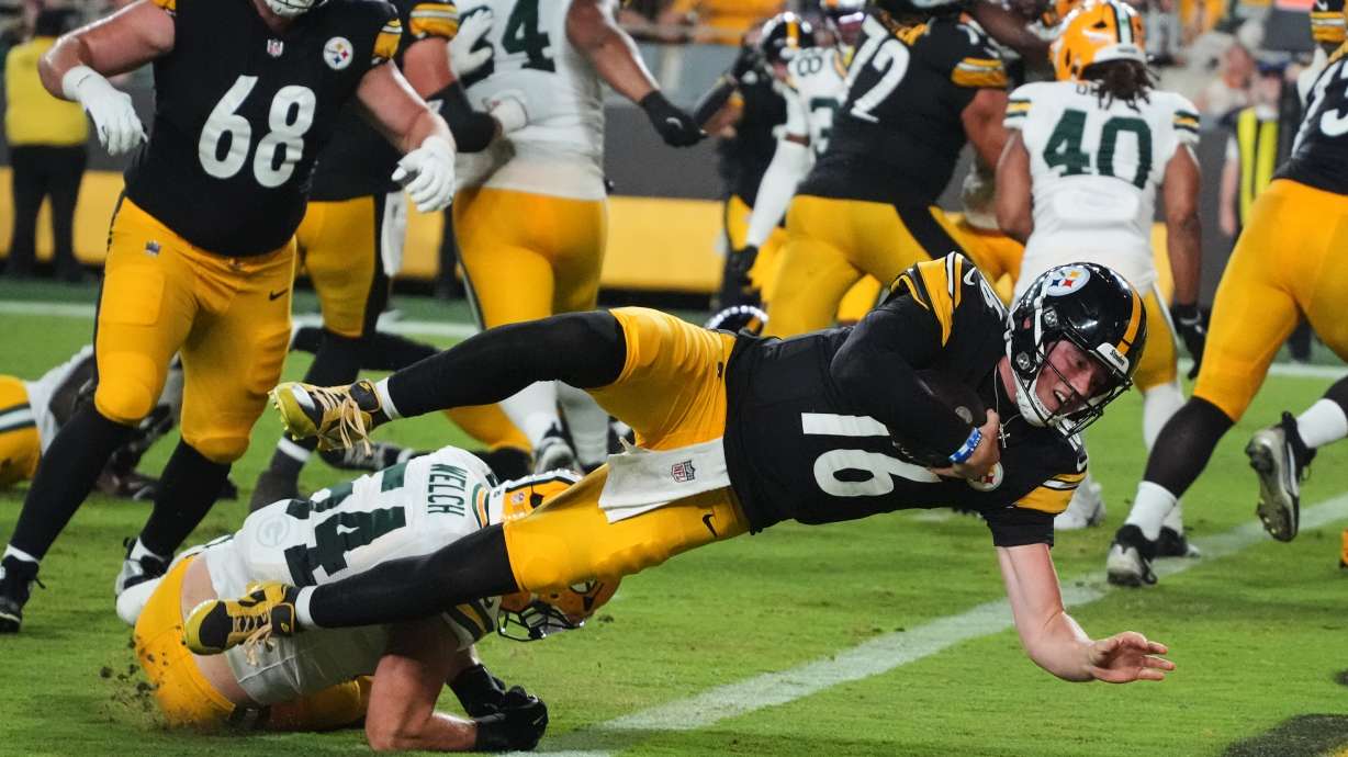 Pittsburgh Steelers quarterback Drew Allar (16) divers over Green Bay Packers linebacker Kristian Welch into the end zone for a touchdown in the second half of a preseason NFL football game in Pittsburgh, Thursday, Aug. 13, 2026.