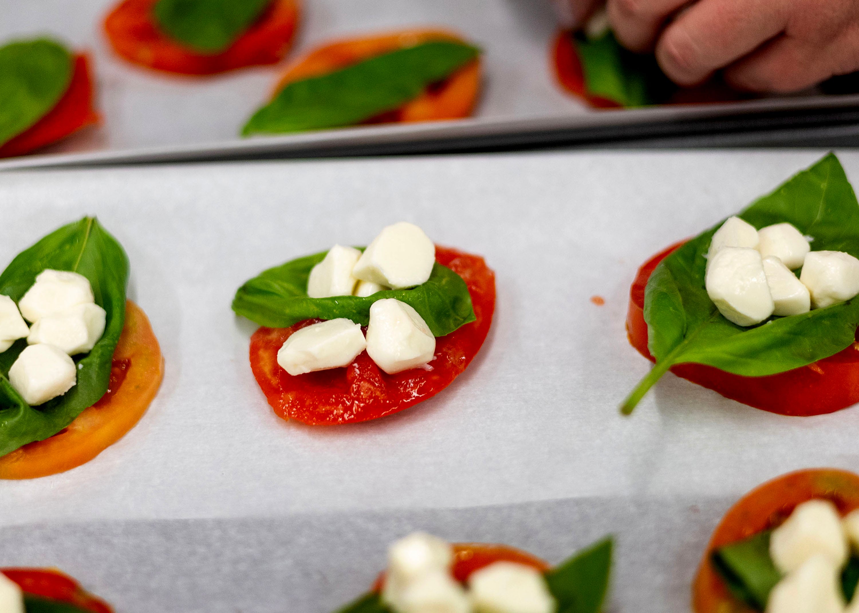 Mozzarella balls are added to a basil and tomato slice during a Fresh Food Friday budget cooking class at Utah Valley University in Orem on Friday.