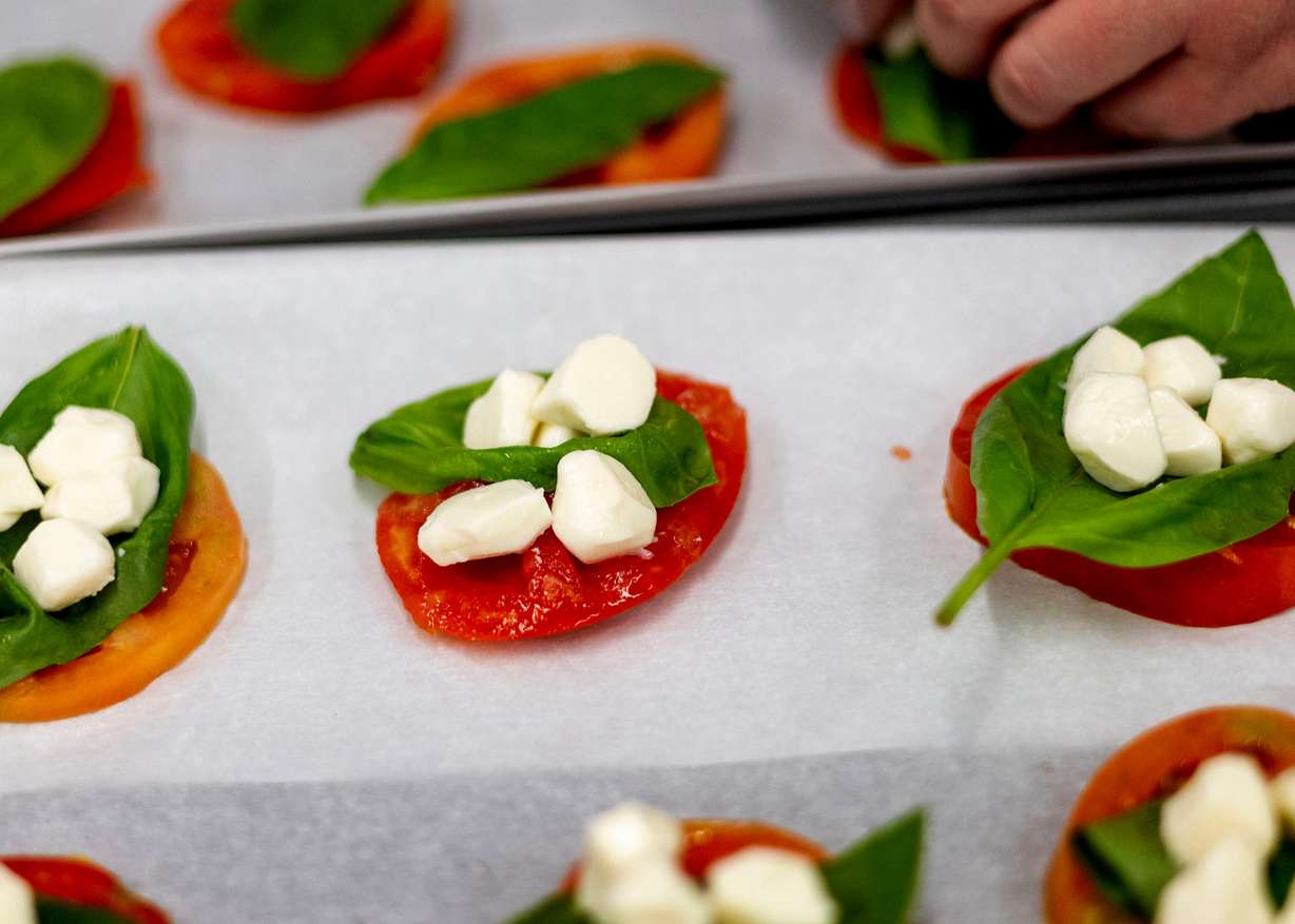 Mozzarella balls are added to a basil and tomato slice during a Fresh Food Friday budget cooking class at Utah Valley University in Orem on Friday.