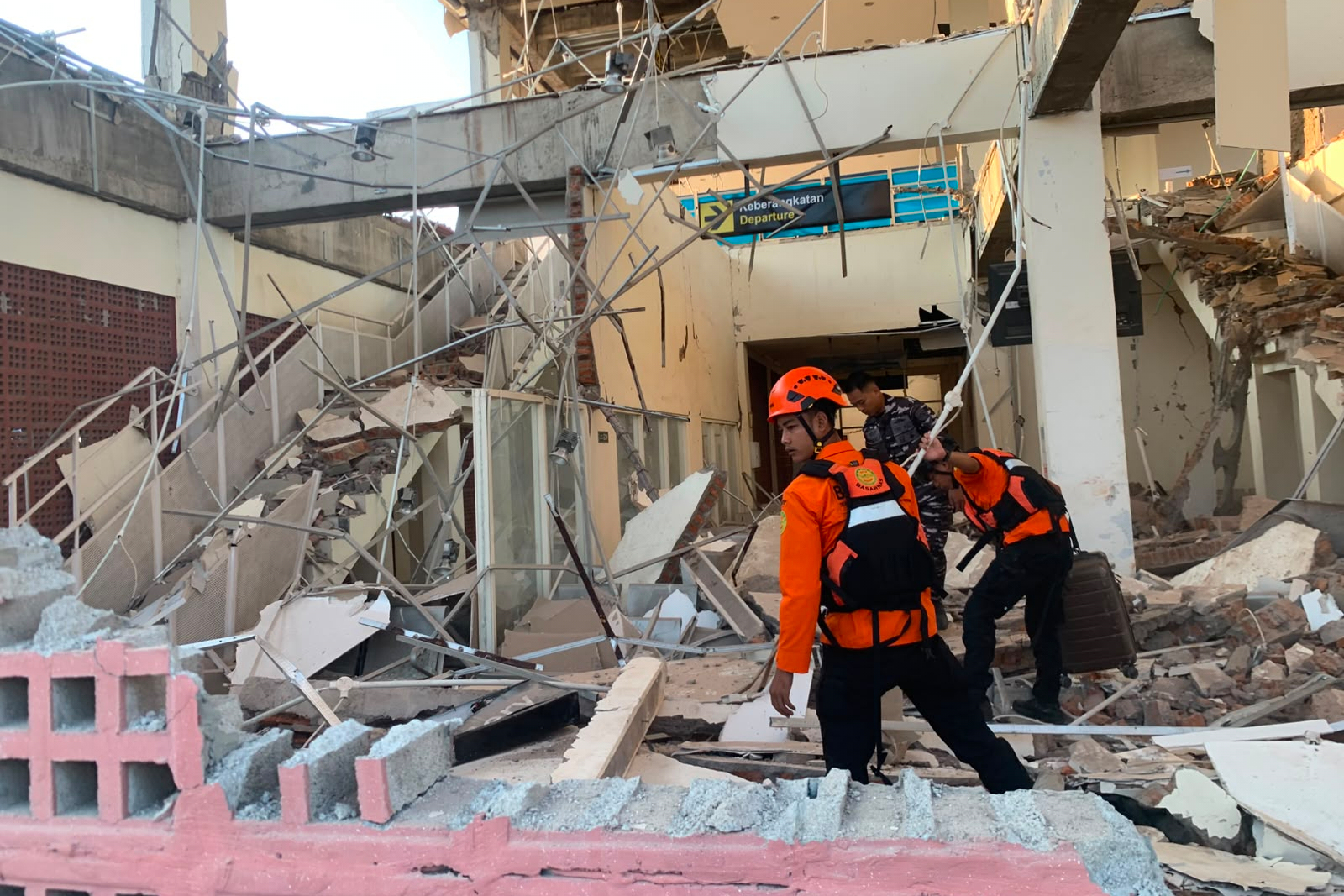 In this photo released by the Indonesian National Search and Rescue Agency (BASARNAS), rescuers search for victims at a damaged building following an earthquake in Maumere, East Nusa Tenggara Province, Indonesia, Saturday.
