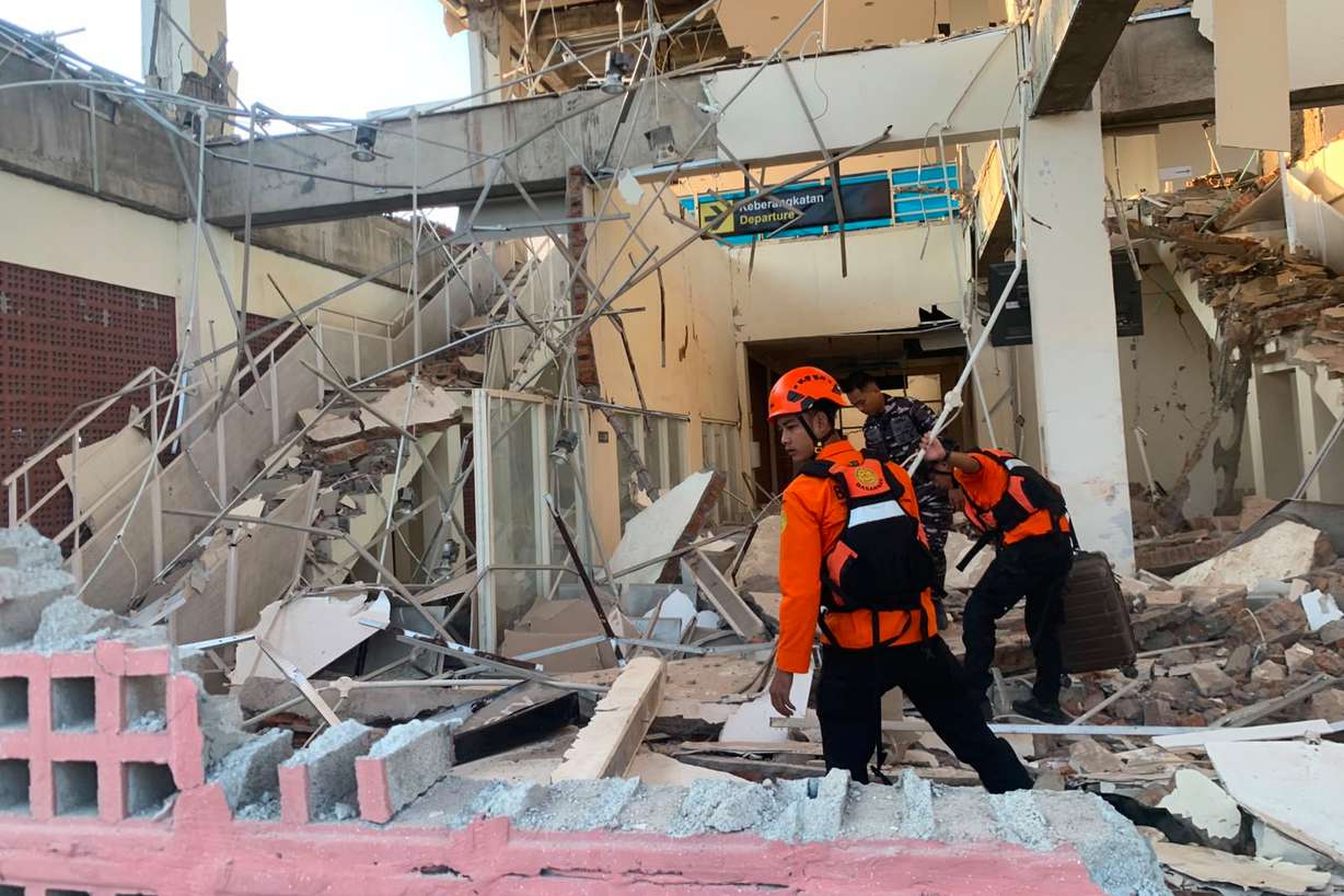 In this photo released by the Indonesian National Search and Rescue Agency (BASARNAS), rescuers search for victims at a damaged building following an earthquake in Maumere, East Nusa Tenggara Province, Indonesia, Saturday.