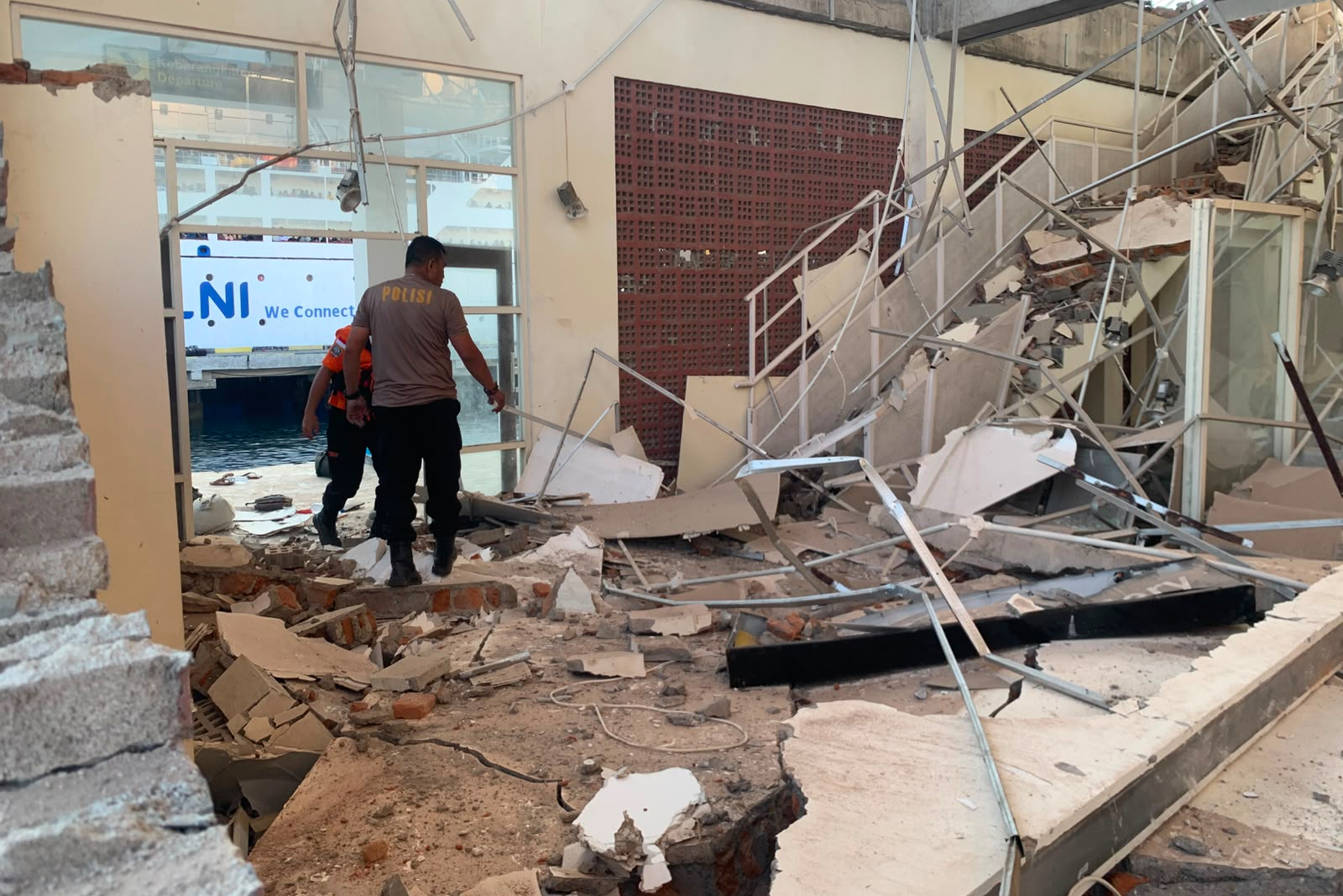 In this photo released by the Indonesian National Search and Rescue Agency (BASARNAS), rescuers inspect a damaged building following an earthquake in Maumere, East Nusa Tenggara Province, Indonesia, Saturday.
