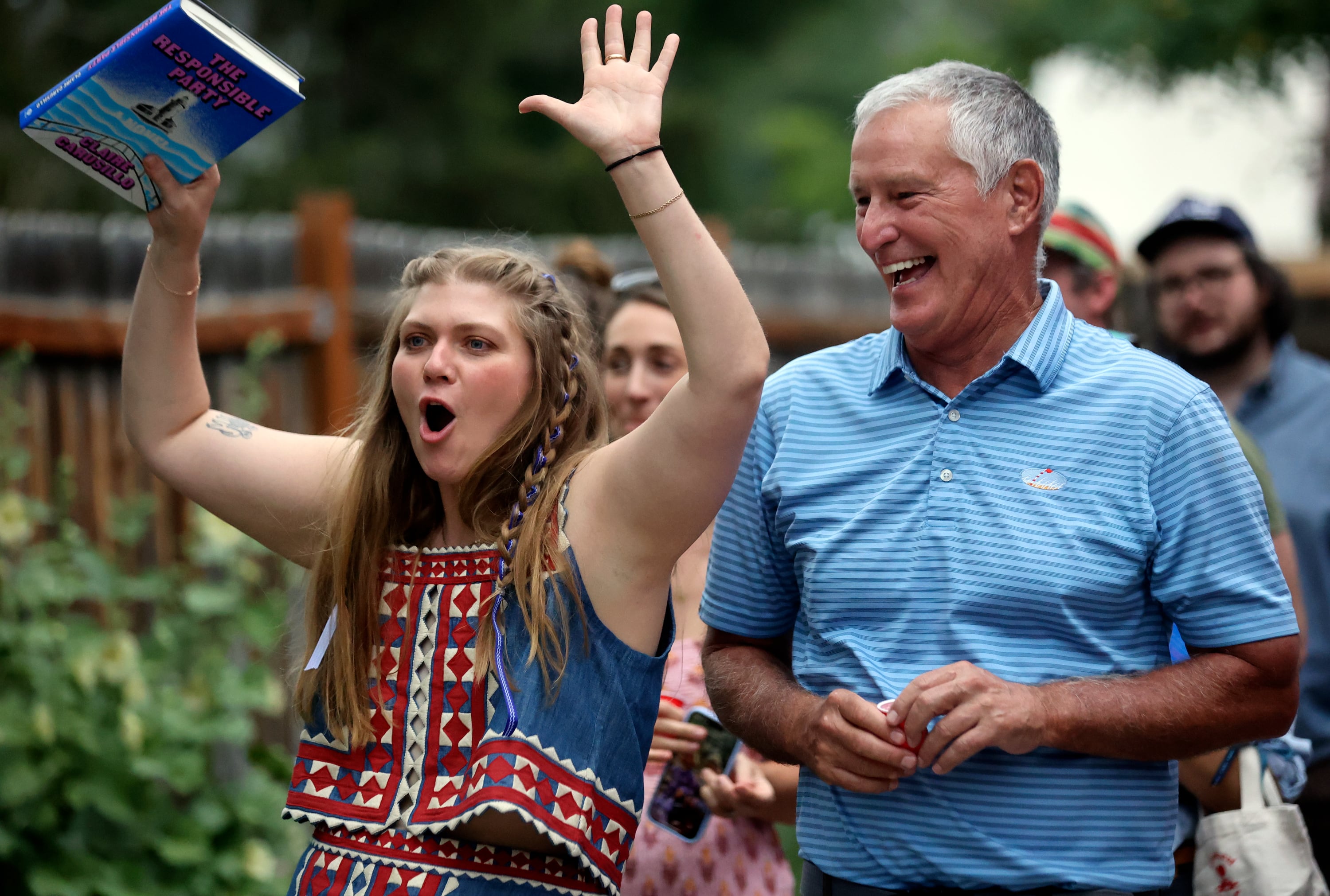 Claire Carusillo and her father Mickey Carusillo react during an opening speech at a book release event for Claire’s novel “The Responsible Party,” at Storyboard book, skate and coffee shop in Midway on Aug. 10. Claire recently opened Storyboard with Galen DeKemper.