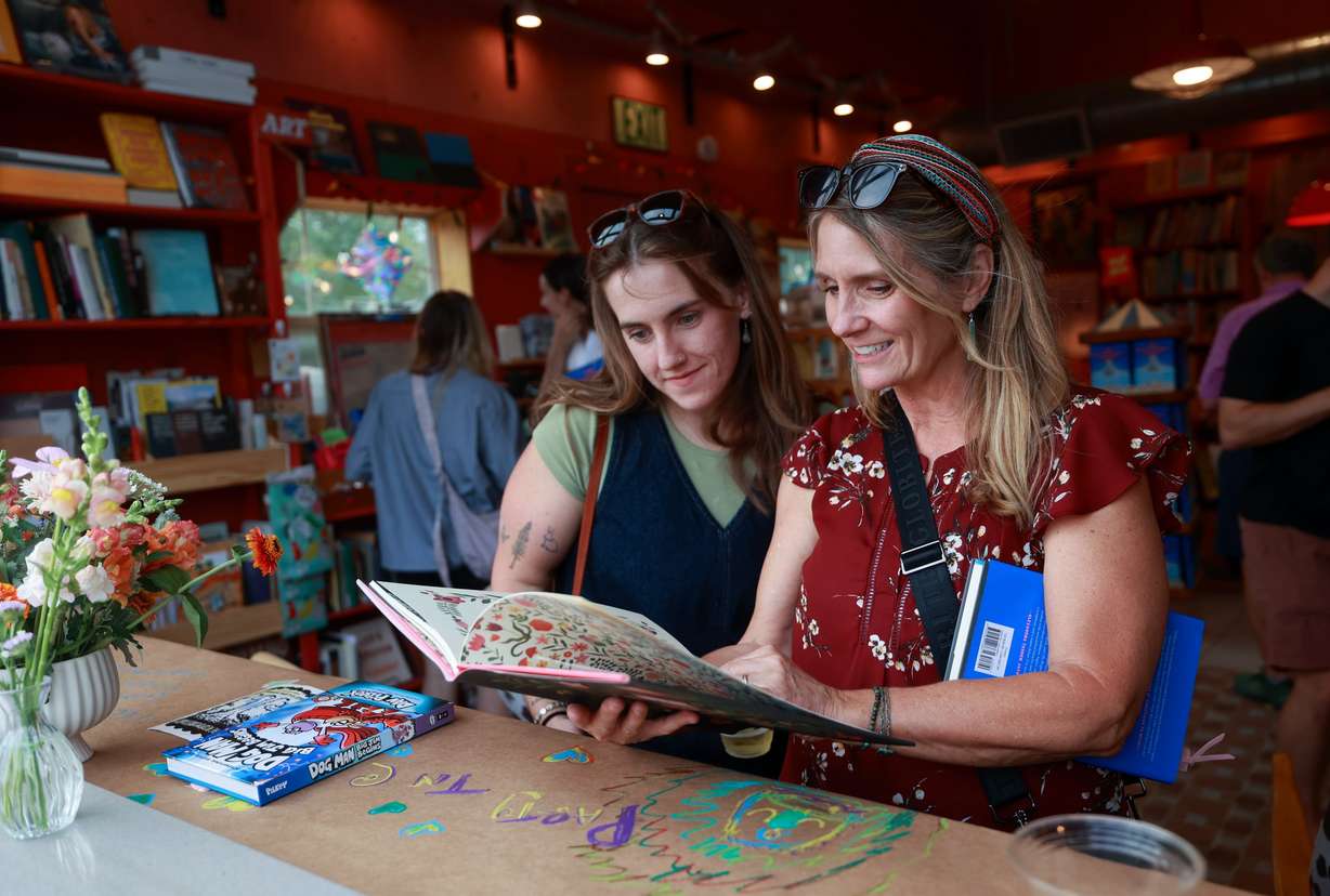 Alicia Bedford and Karen Gleeson look at a book at Storyboard book, skate and coffee shop in Midway on Aug. 10.
