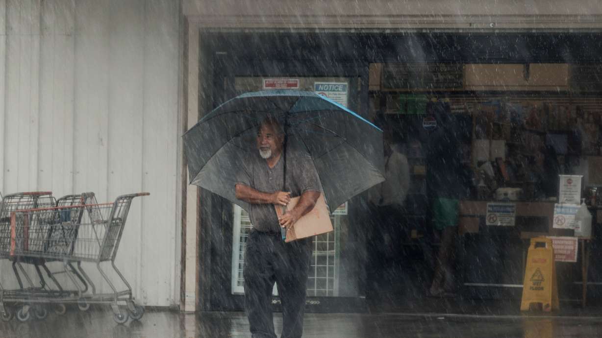 A resident carries supplies during Hurricane Lala in Hawaiian Ocean View, Hawaii, Saturday.