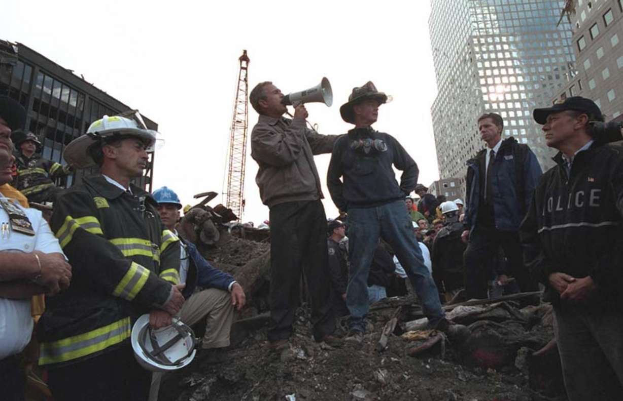 Standing atop rubble with retired New York City firefighter Bob Beckwith, President George W. Bush addresses about 400 police, firemen and rescue workers by bullhorn at the site of the collapsed World Trade Center in New York City. September 14, 2001.