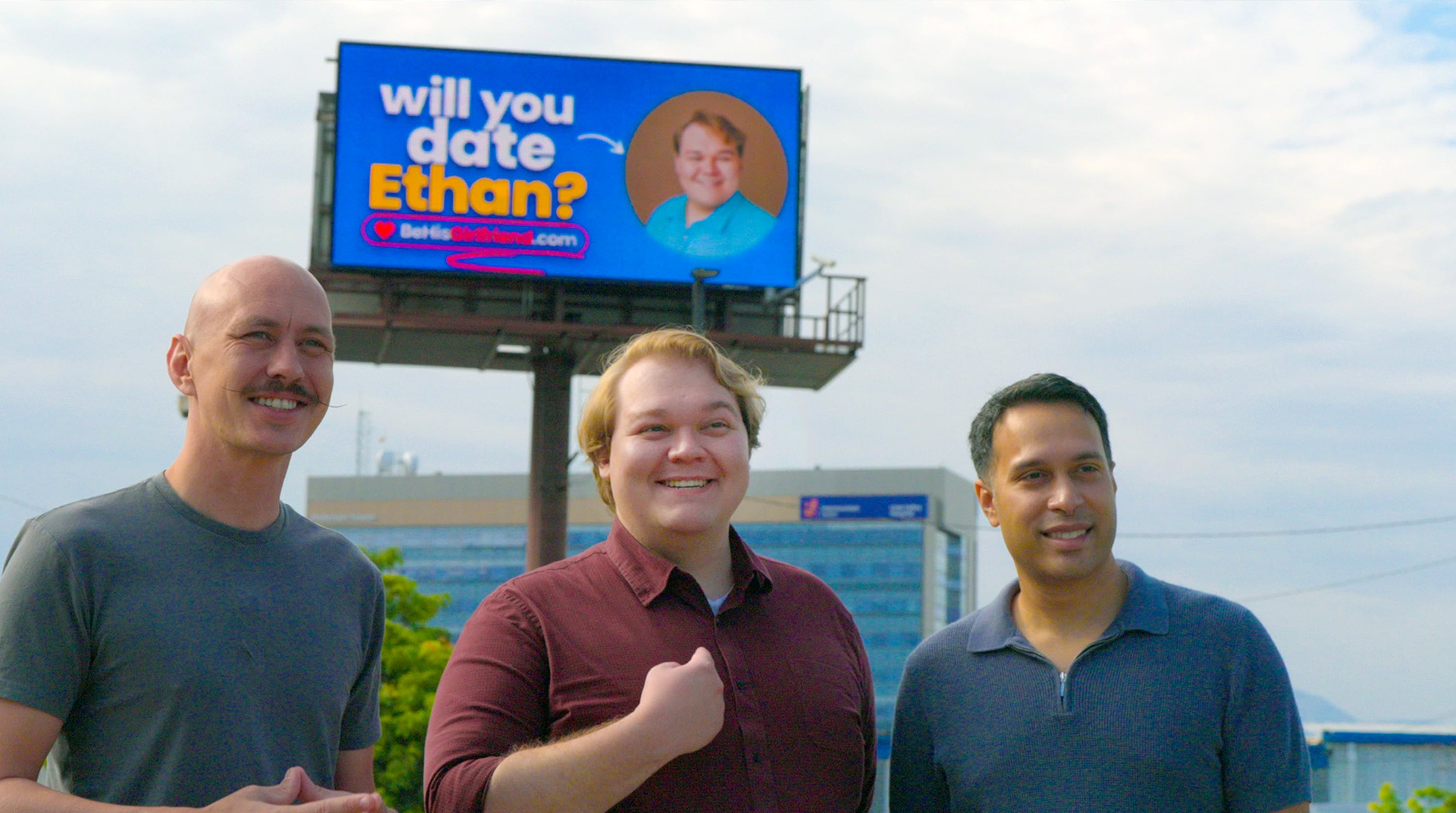 Ethan Van Valkenburg, center, stands beside Derek Anderson, left, an Altlas:Earth marketing associate, and Sami Khan, right, Utah CEO and founder of Atlas:Earth, in front of his billboard in Provo, Utah.