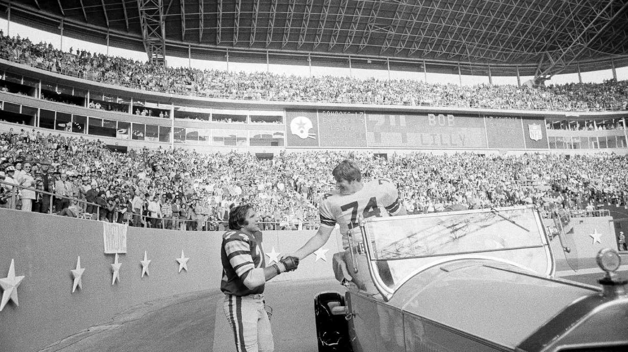 FILE - Philadelphia Eagles guard John Niland (74), right, shakes hands with retired Dallas Cowboys tackle Bob Lilly (74) during half-time ceremonies honoring Lilly at Texas Stadium in Irving, Nov. 23, 1975. Niland and Lilly were teammates the previous year.